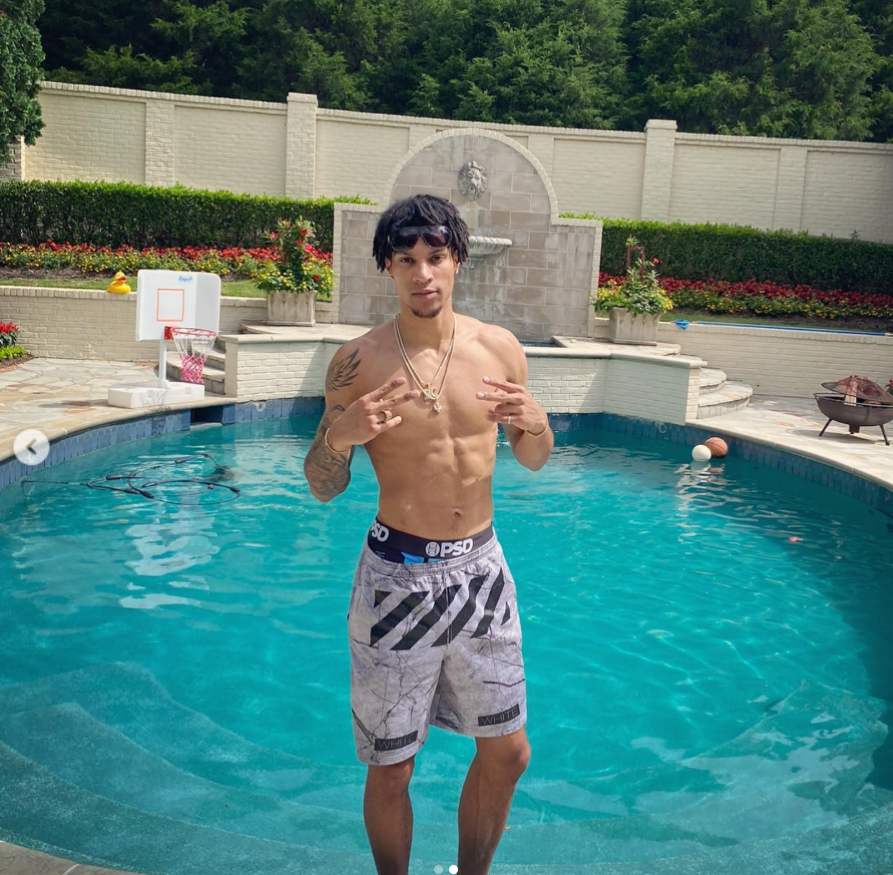 Brandon Clarke flashes hand signs while posing shirtless in front of the swimming pool. | Source: Instagram/brandon_clarke23