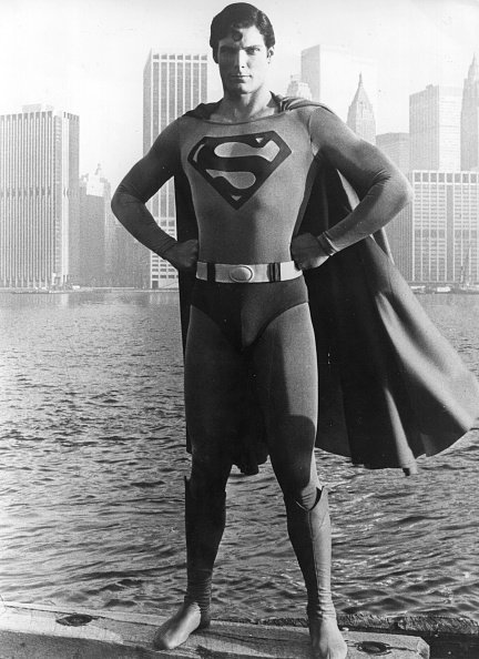 Christopher Reeve steht vor der Skyline von Manhattan, gekleidet wie der Comic-Held aus dem Film "Superman". | Quelle: Getty Images