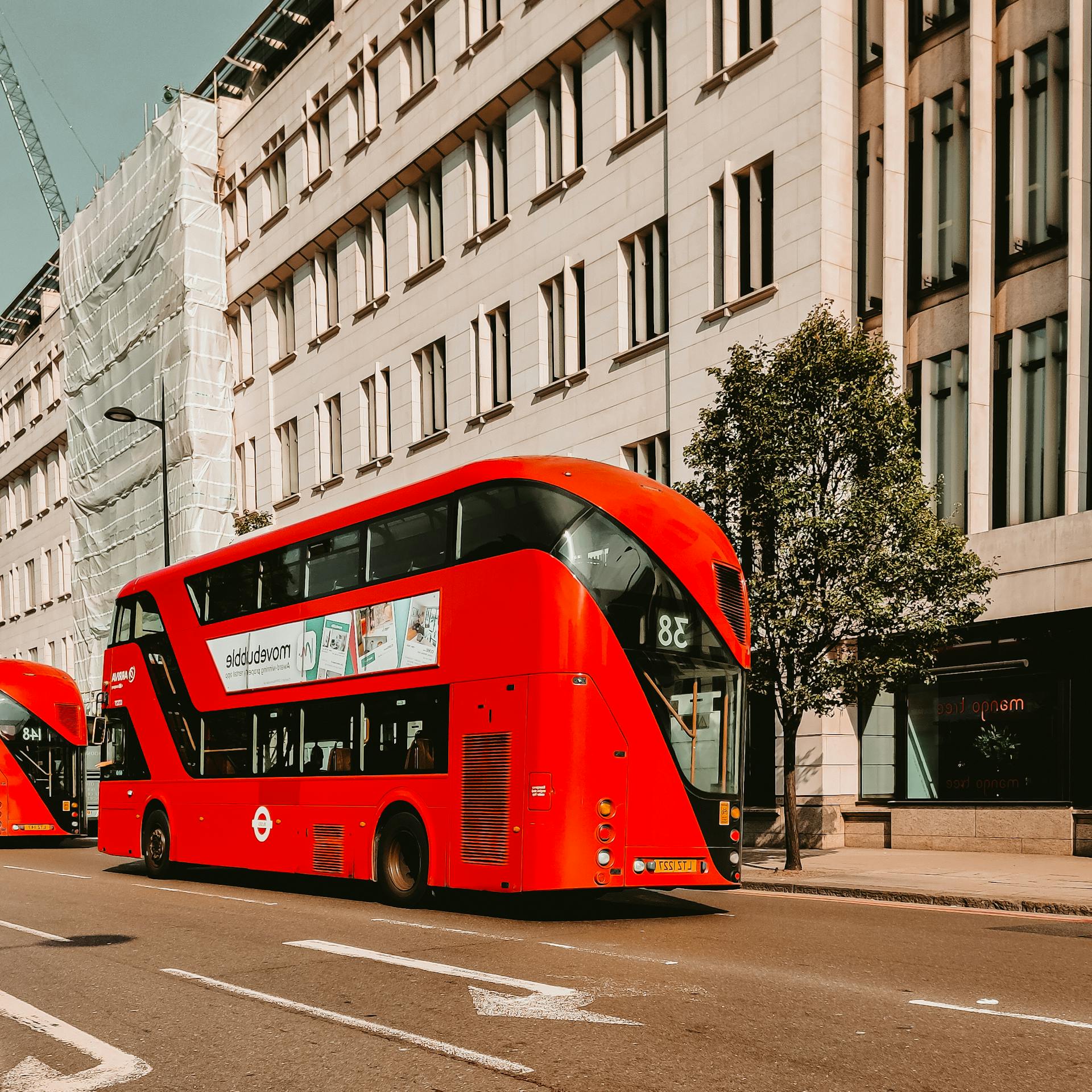 A red double-decker bus passing by a street in the city | Source: Pexels