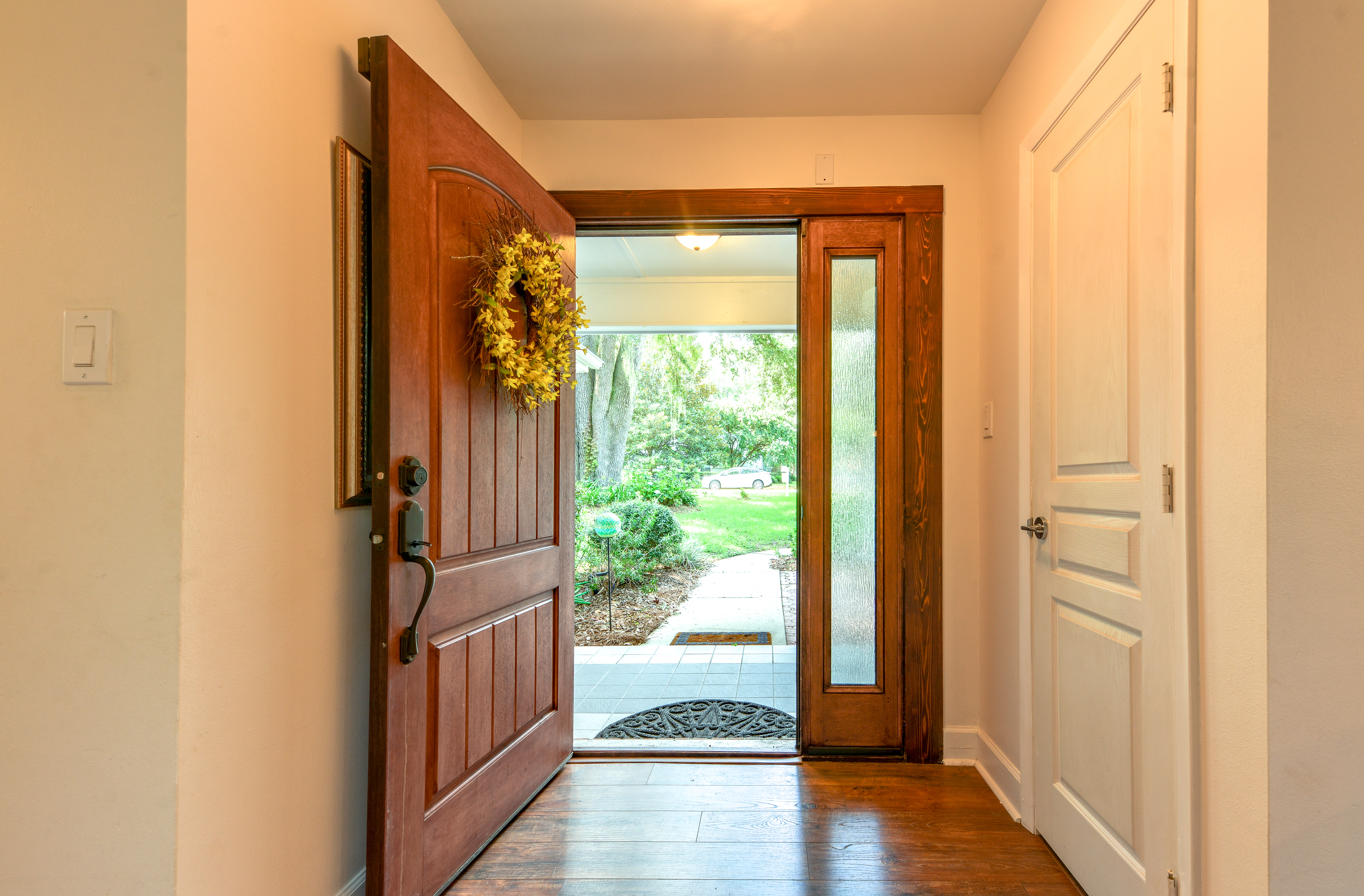 Eine offene Haustür mit einem Kranz darüber | Quelle: Shutterstock
