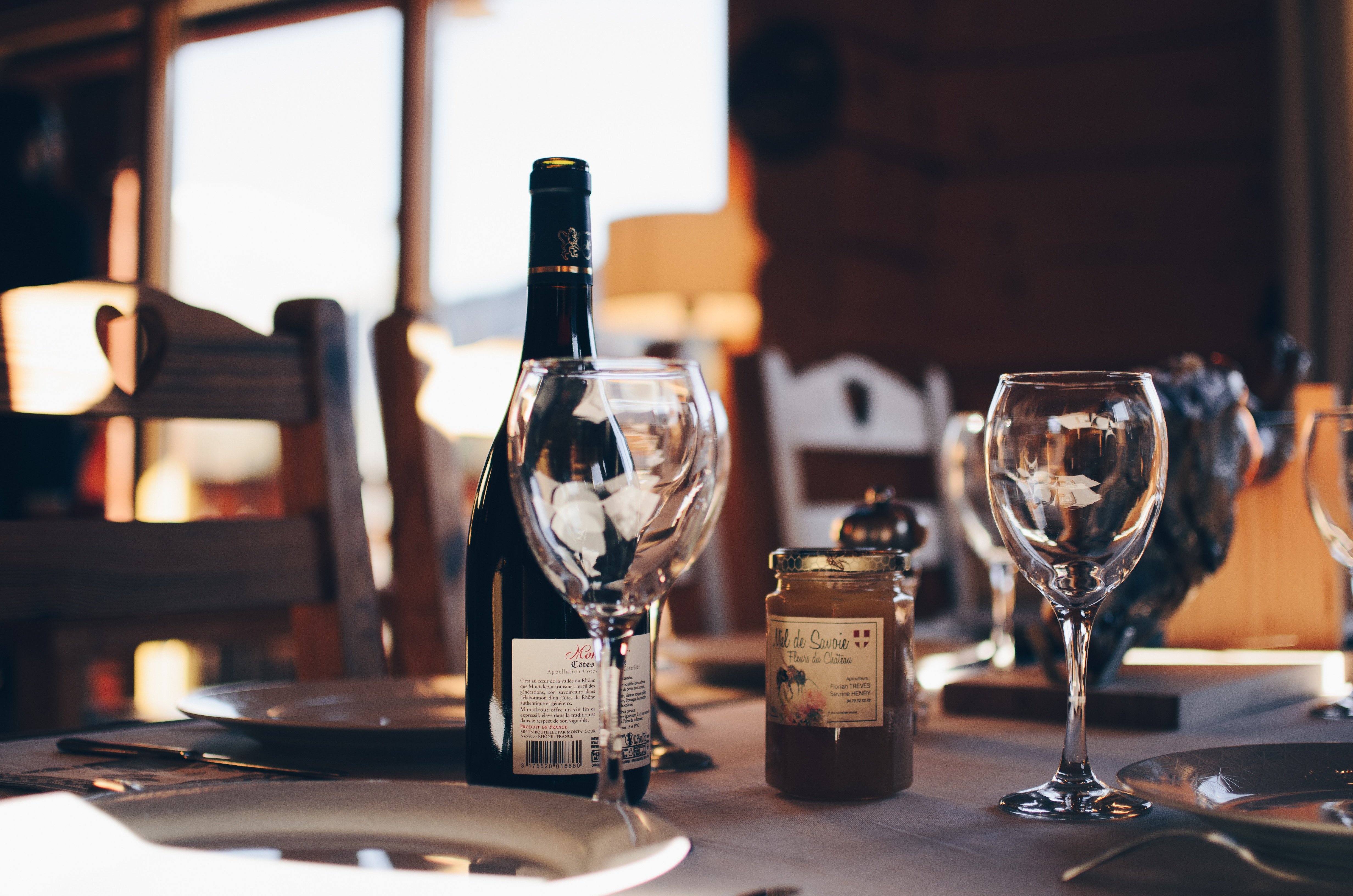 Une photo de deux verres à vin vides et d'une bouteille de vin | Source : Unsplash
