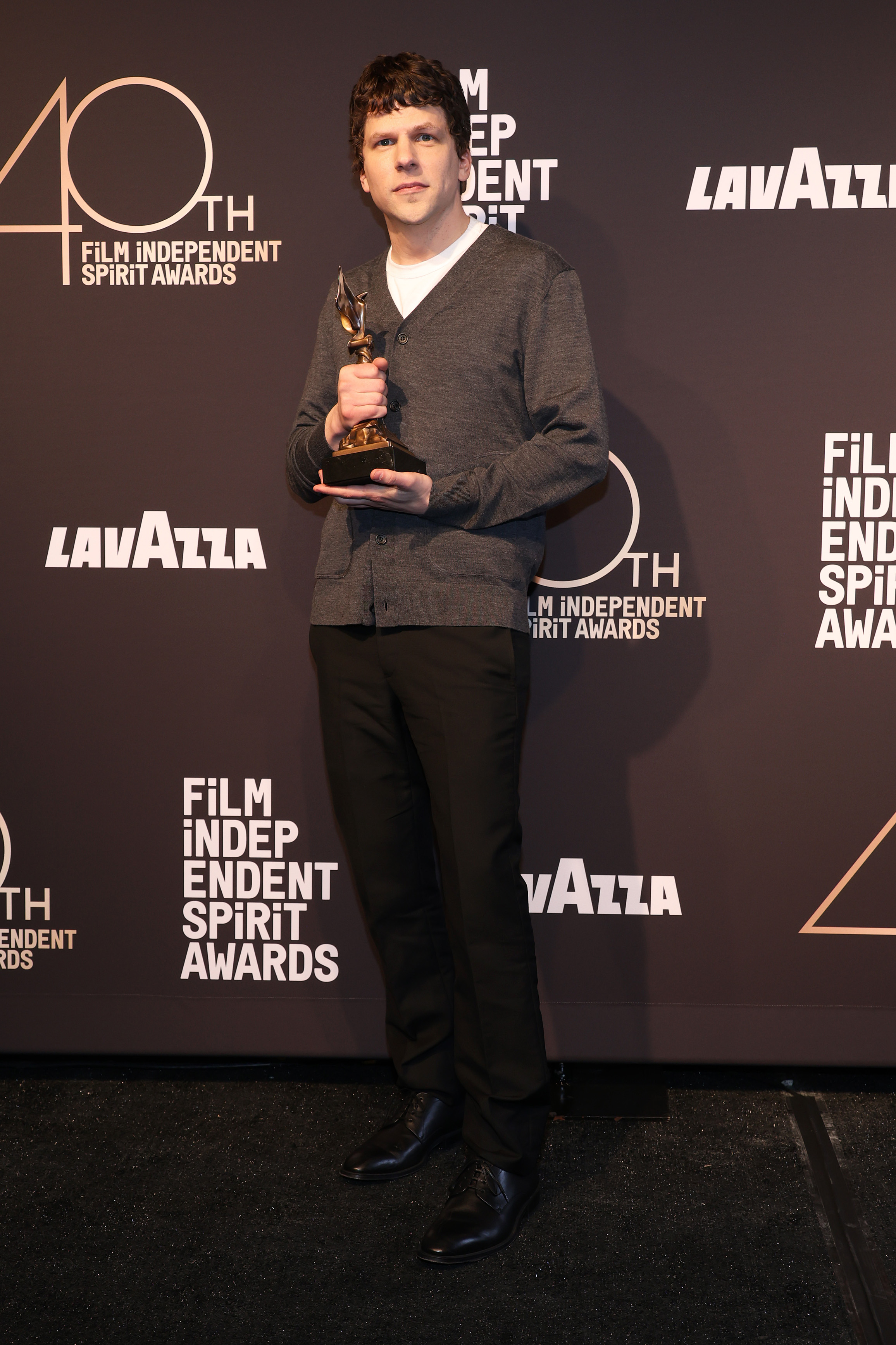 Jesse Eisenberg posing with his Best Screenplay award for "A Real Pain" during the Film Independent Spirit Awards in Santa Monica, California on February 22, 2025. | Source: Getty Images