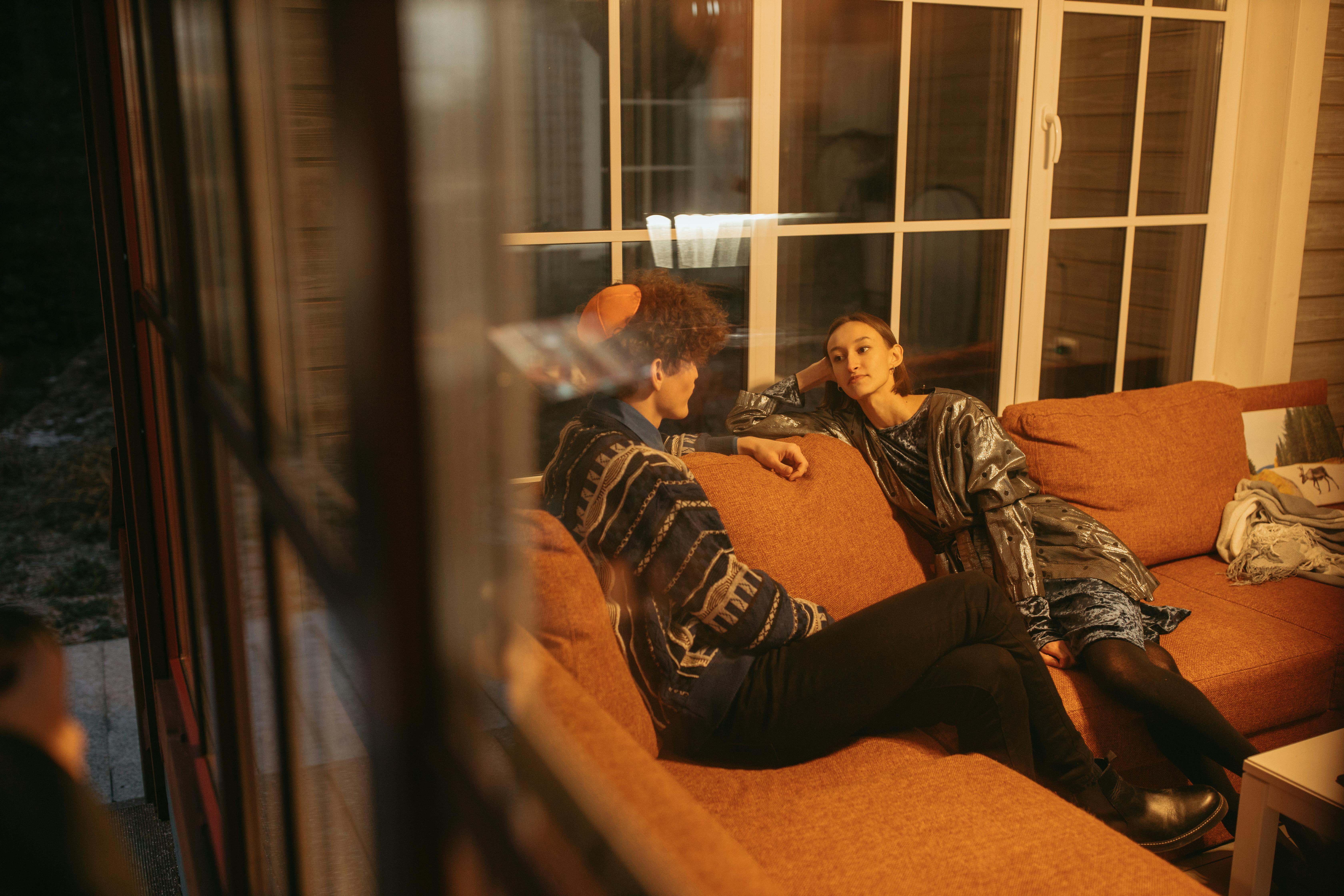 A woman and man conversing on a sofa in an apartment | Source: Pexels