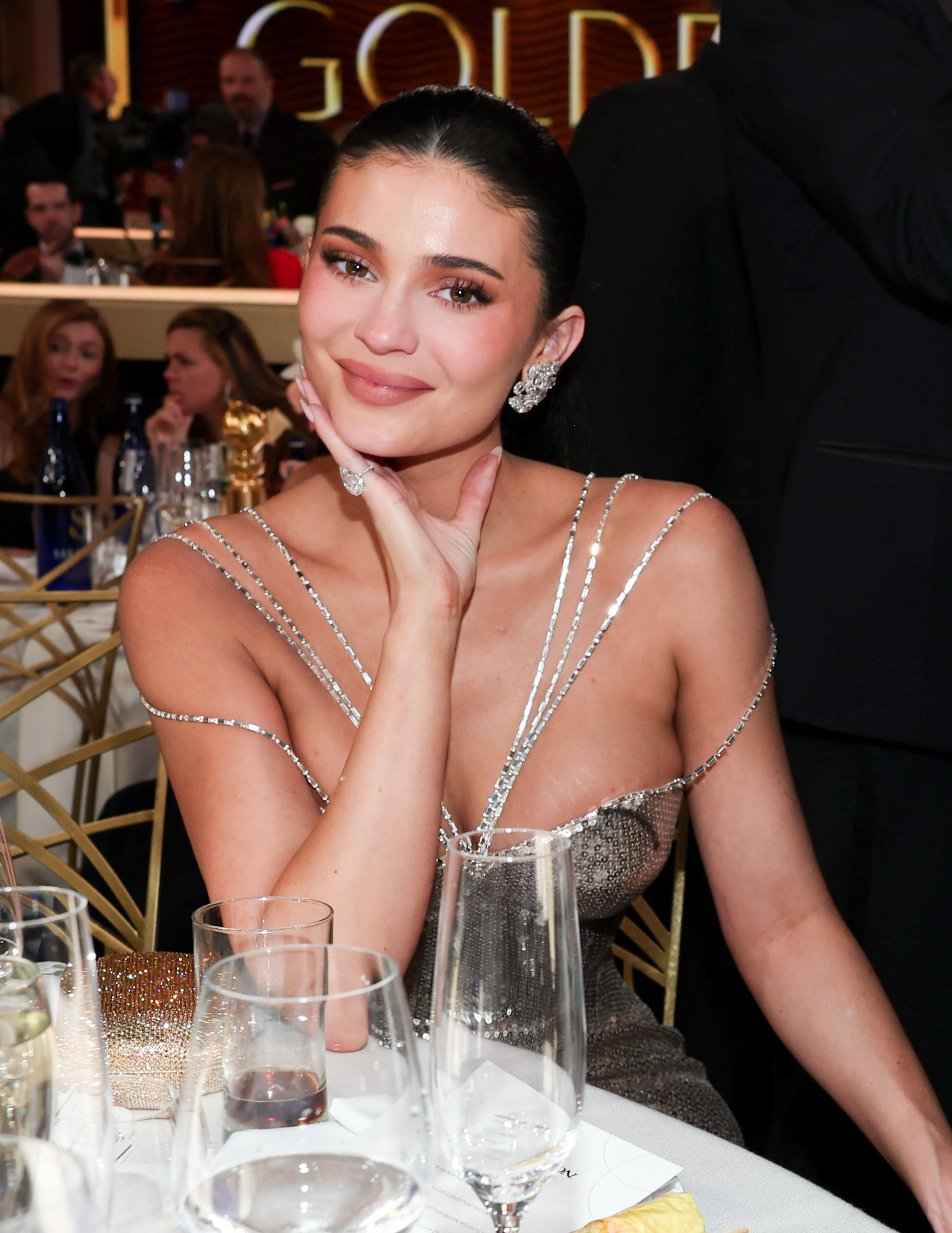 Kylie Jenner poses solo at her table with a soft smile and sparkling look | Source: Getty Images