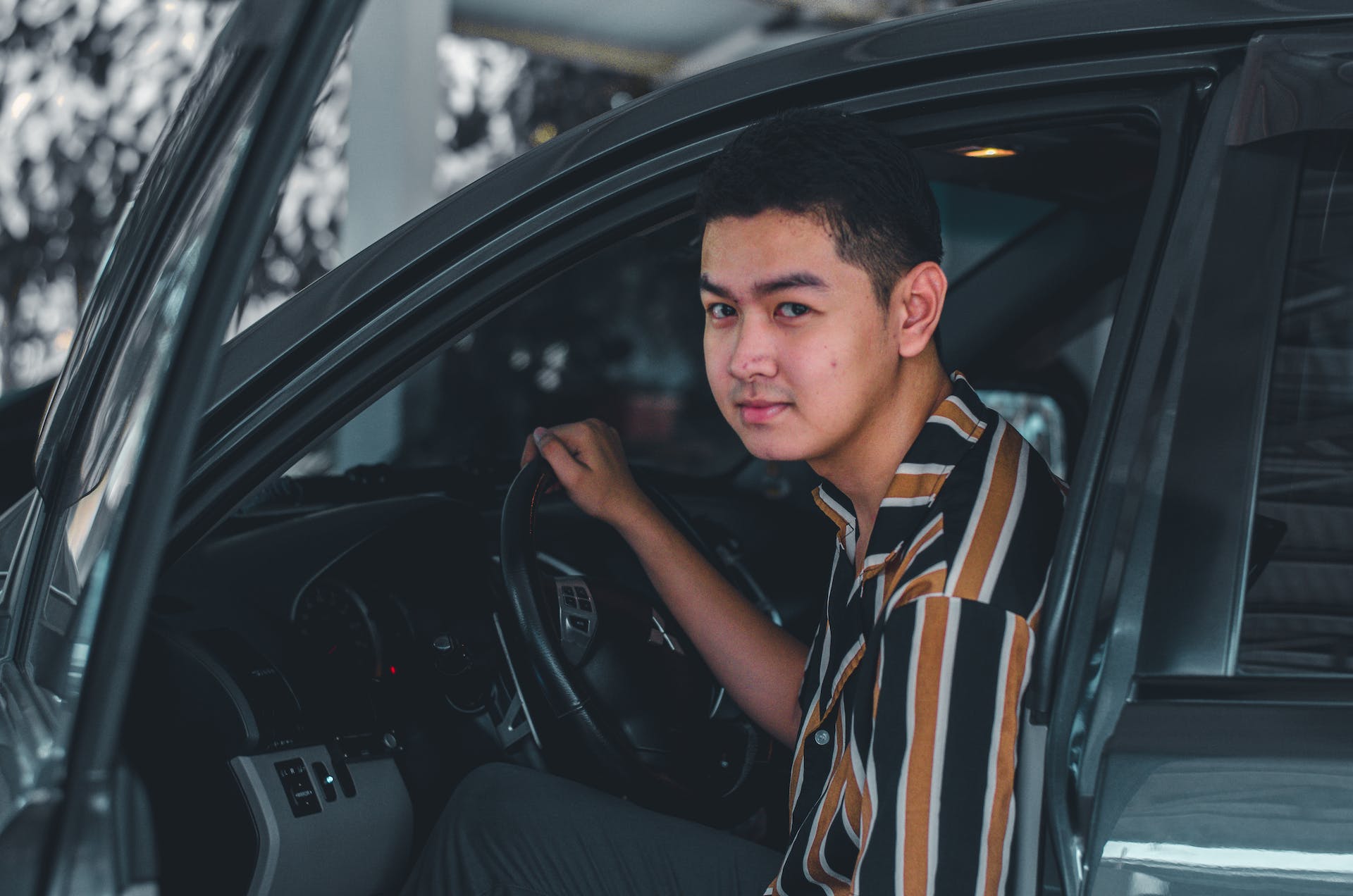 A young man holding a steering wheel | Source: Pexels