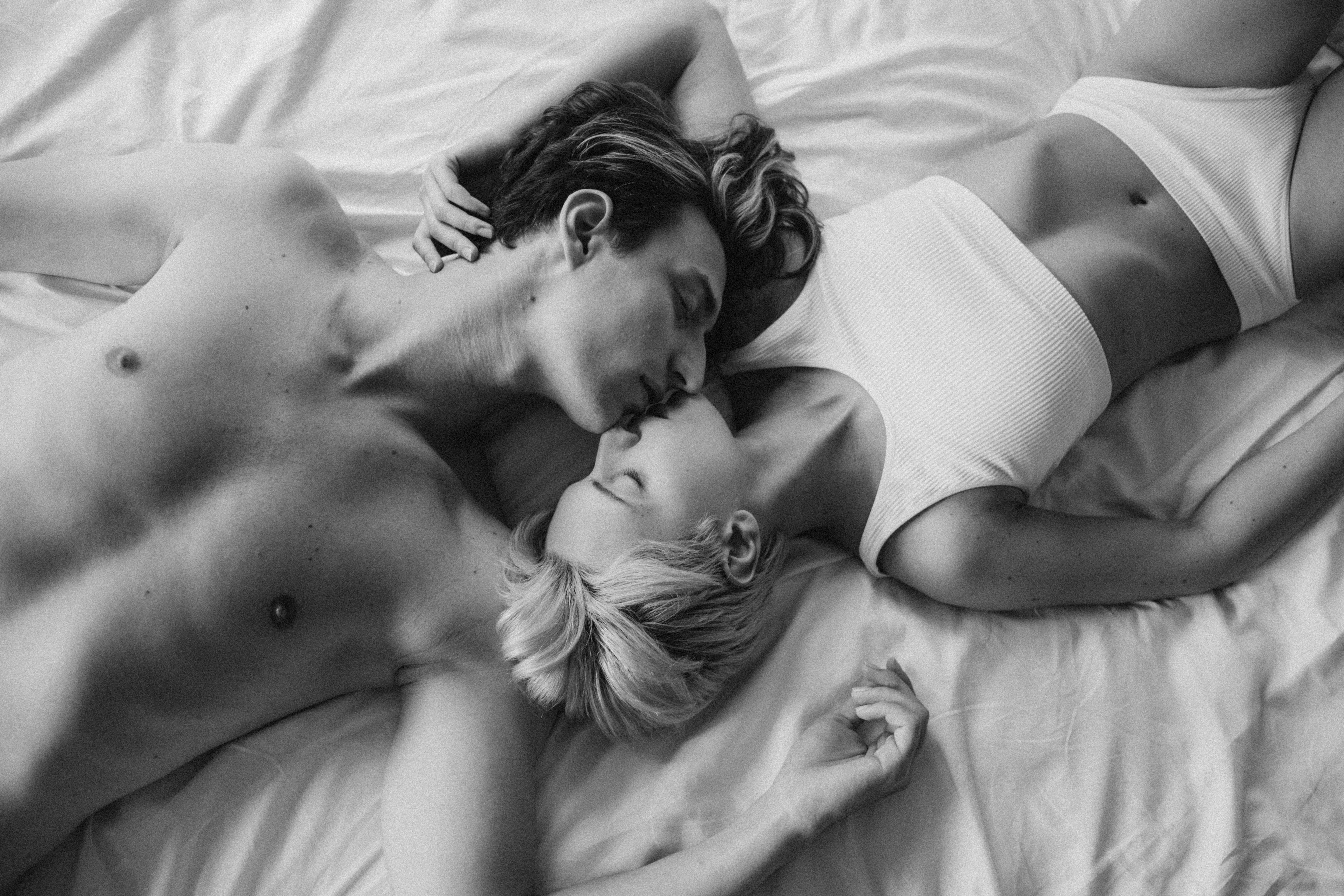 A couple almost kissing while lying in bed. | Source: Pexels
