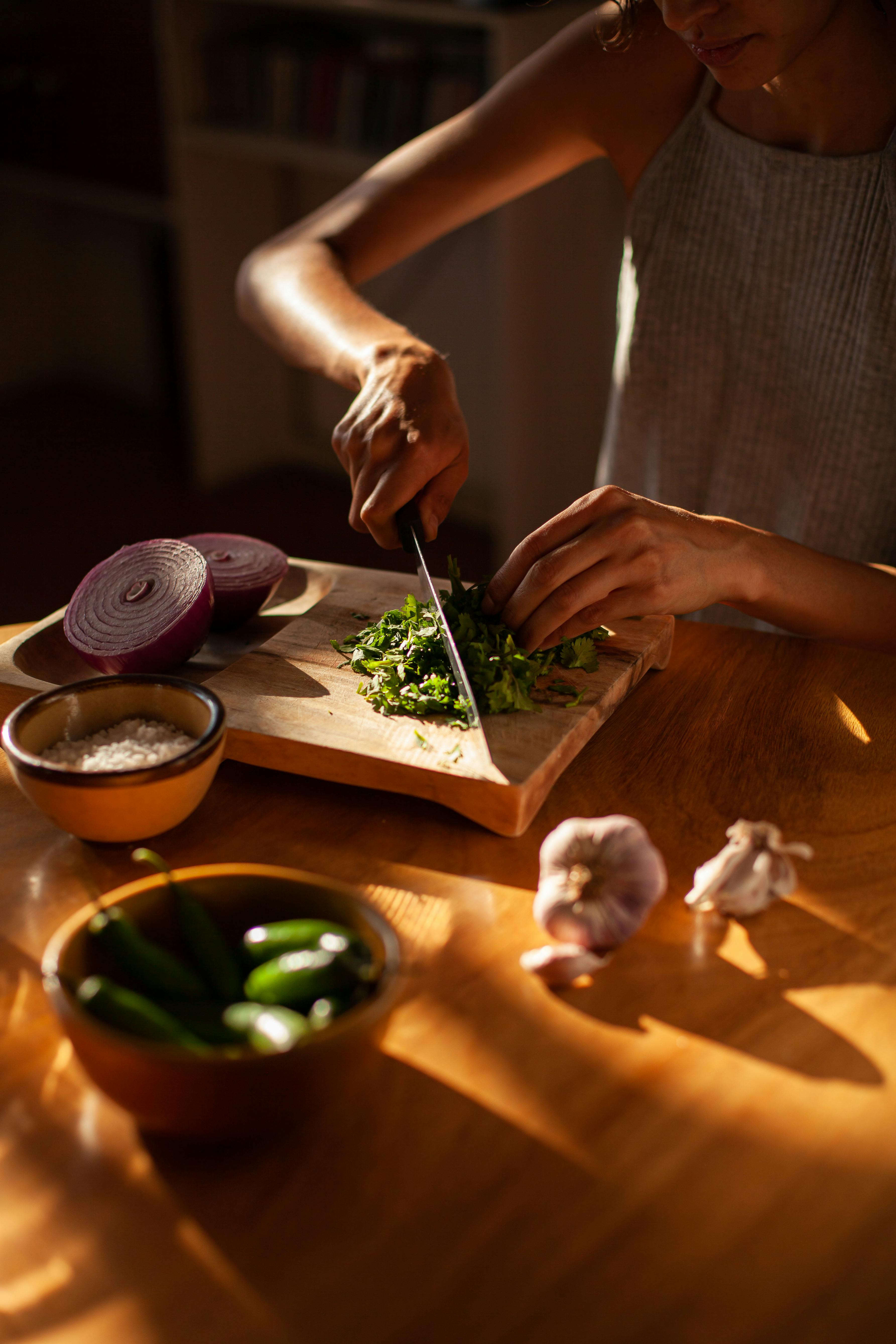 A woman chopping onions | Source: Pexels