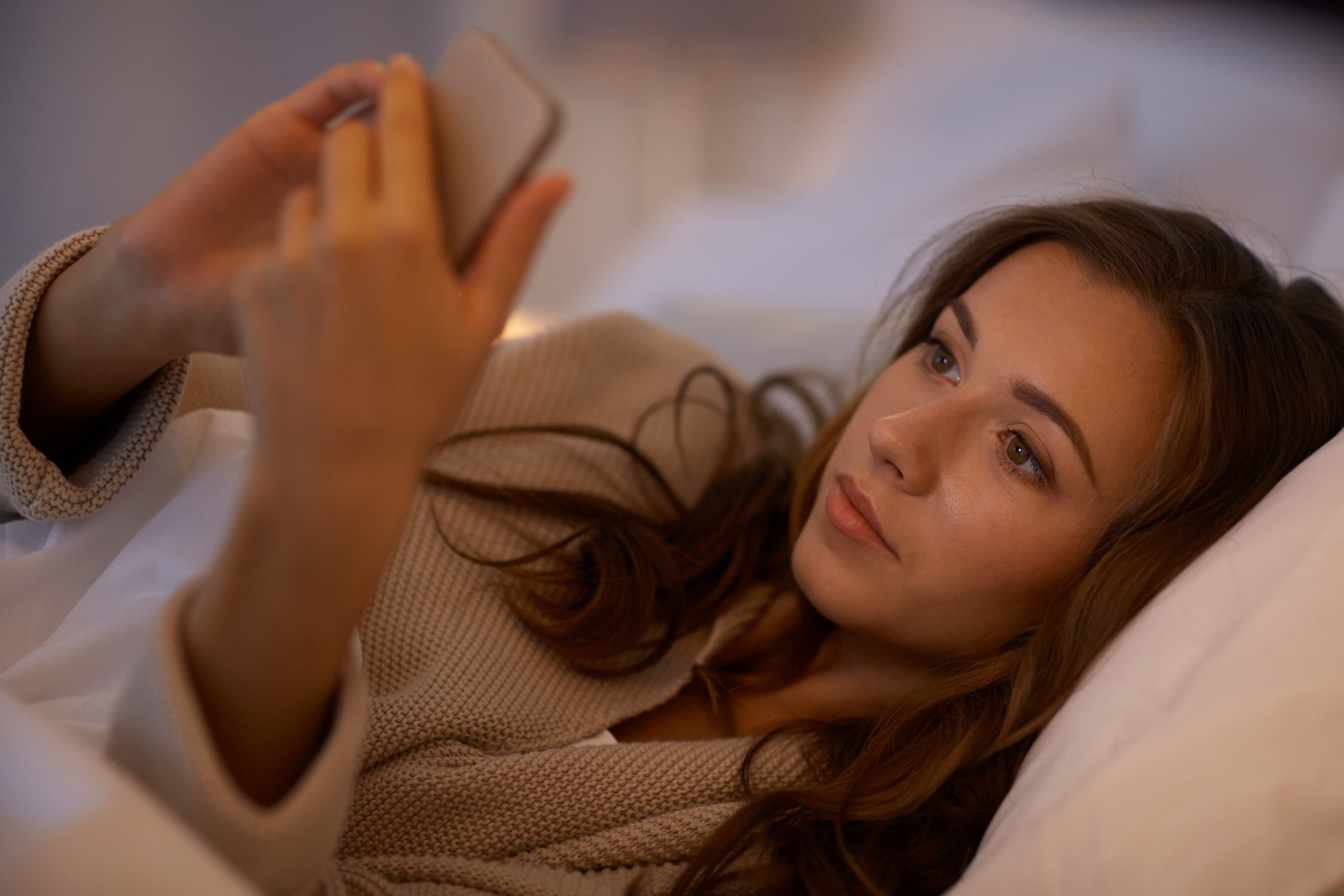 A woman on her phone in bed | Source: Shutterstock