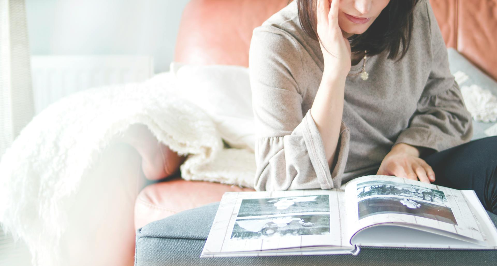 A woman looking at a photo album | Source: Pexels