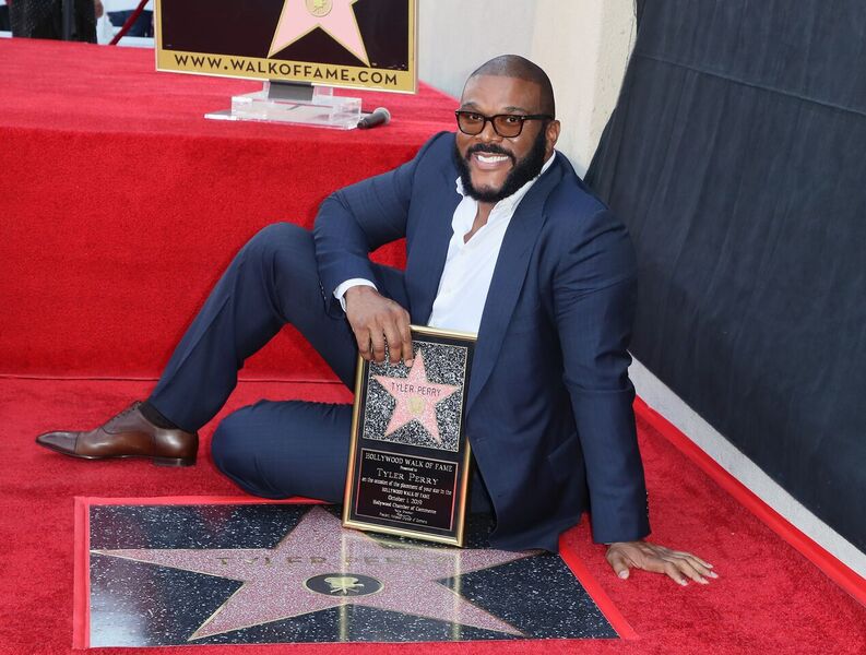 Tyler Perry posing beside his Hollywood Star | Source: Getty Images/GlobalImagesUkraine