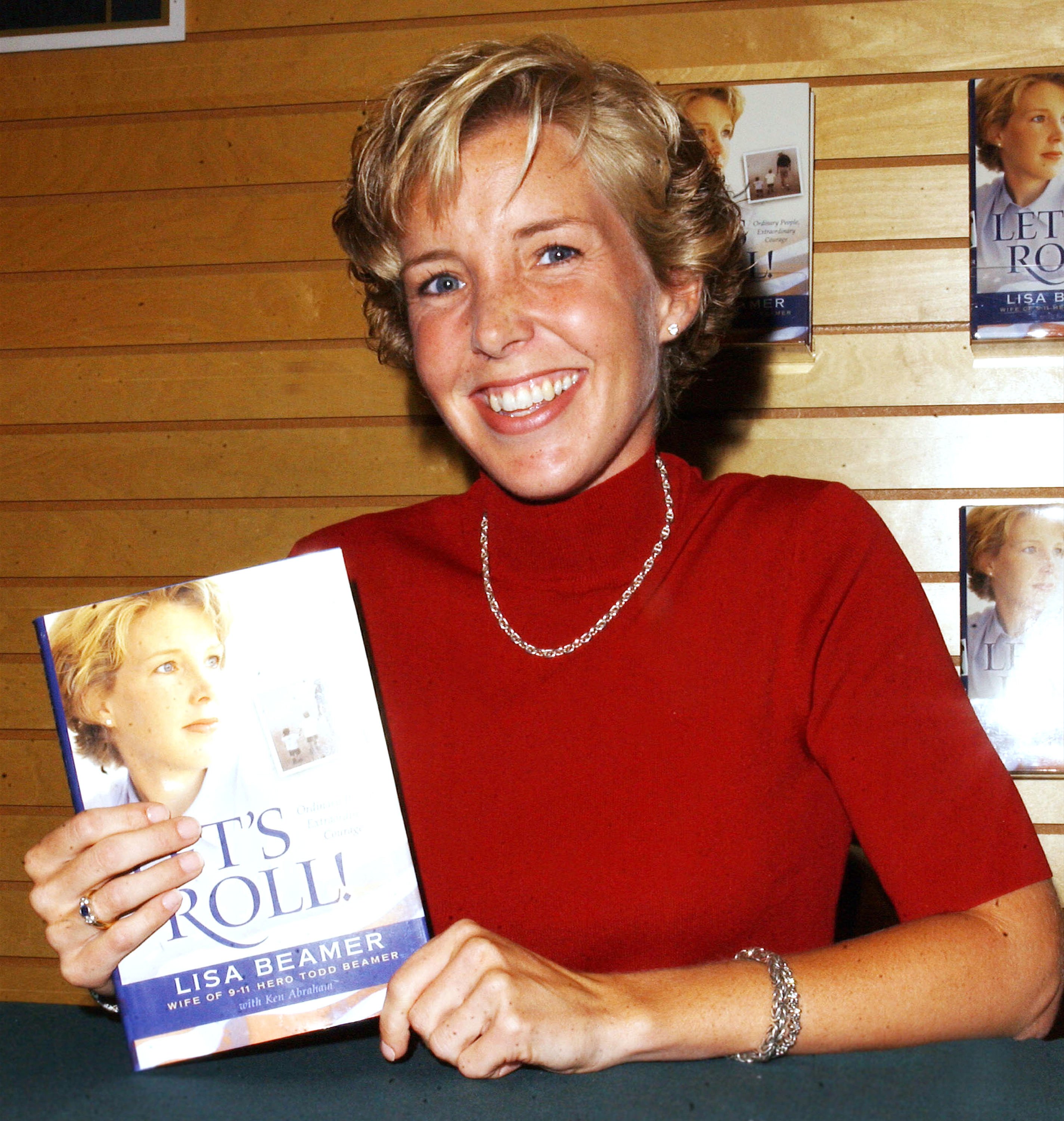 Lisa Beamer posing with a copy of her book "Let's Roll! Ordinary People, Extraordinary Courage" on August 21, 2002, in Los Angeles | Source: Getty Images