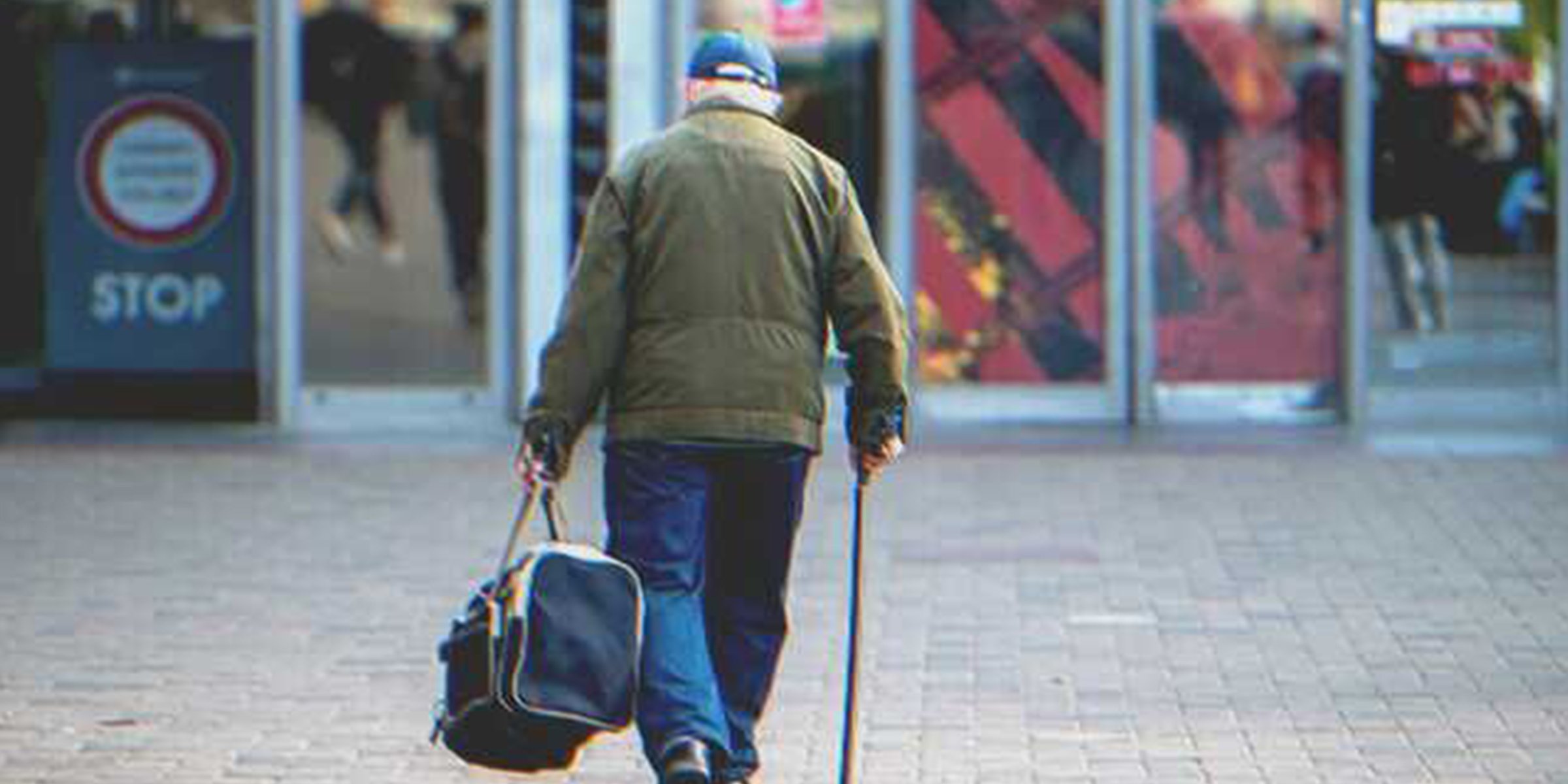 Un vieil homme marche avec un sac | Shutterstock   