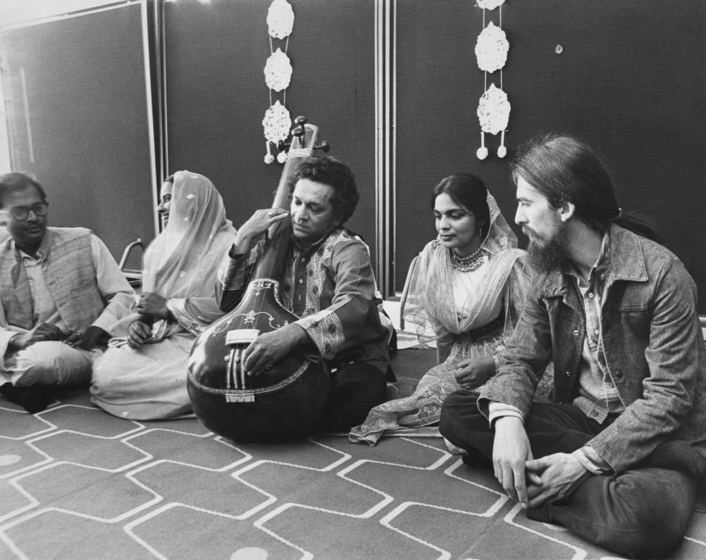 British musician George Harrison of the Beatles (1943 - 2001, right) with a company of seven top Indian instrumentalists, singers and dancers, including Ravi Shankar (centre, on sitar) at a press reception at the Royal Festival Hall in London | Getty Images / Global Images Ukraine British musician George Harrison of the Beatles (1943 - 2001, right) with a company of seven top Indian instrumentalists, singers and dancers, including Ravi Shankar (centre, on sitar) at a press reception at the Royal Festival Hall in London | Getty Images / Global Images Ukraine