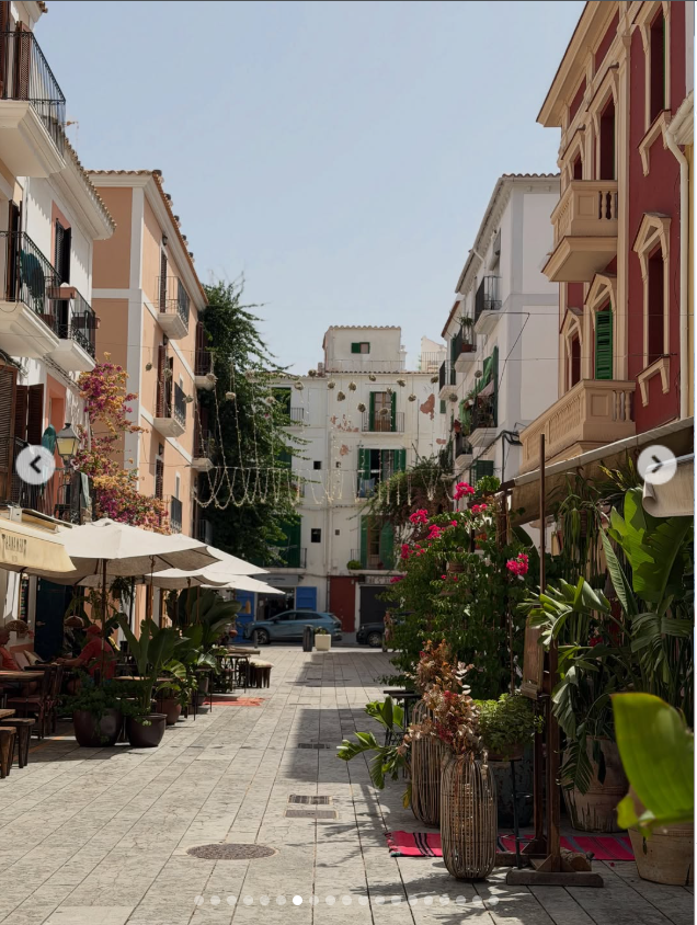 The vacation album also highlighted the charm of Ibiza itself, with one photo capturing a peaceful café-lined street filled with colorful buildings and blooming flowers under the Mediterranean sun. | Source: Instagram/renee__stewart