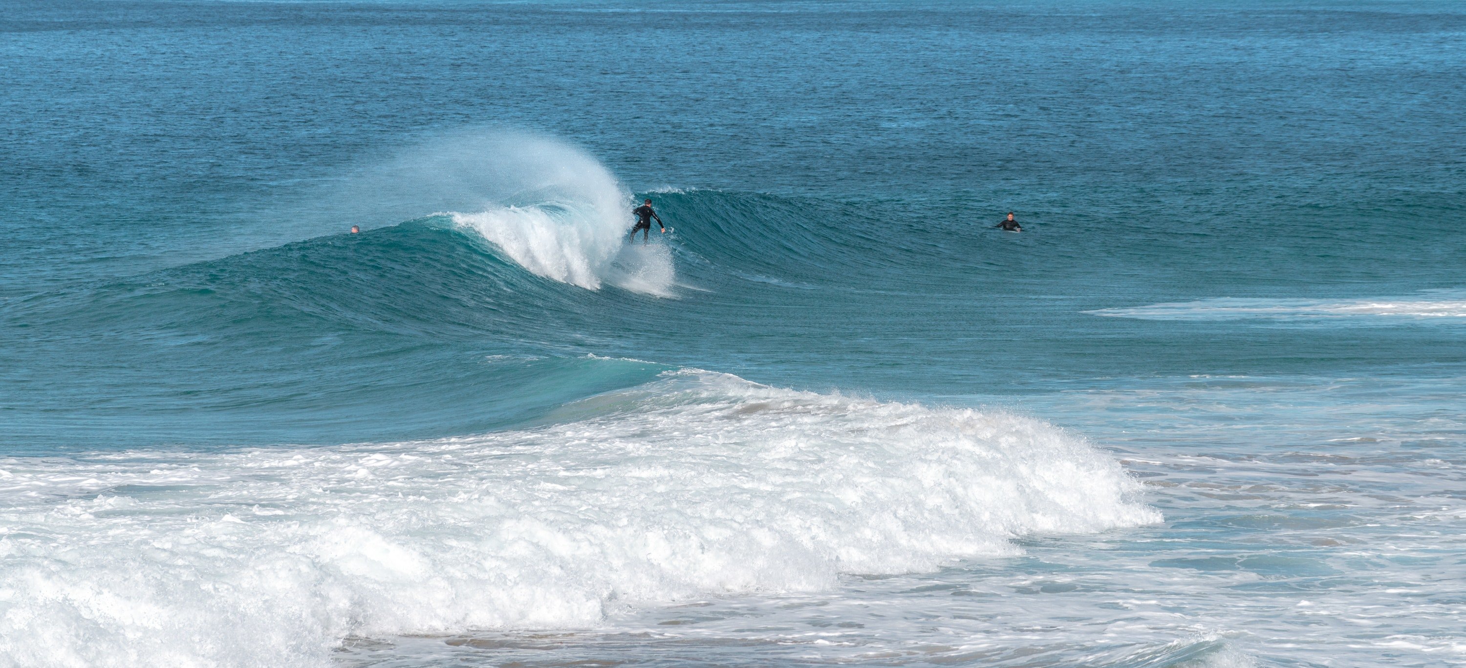 Surfer riding a blue wave. | Pexels/ Ben Mack