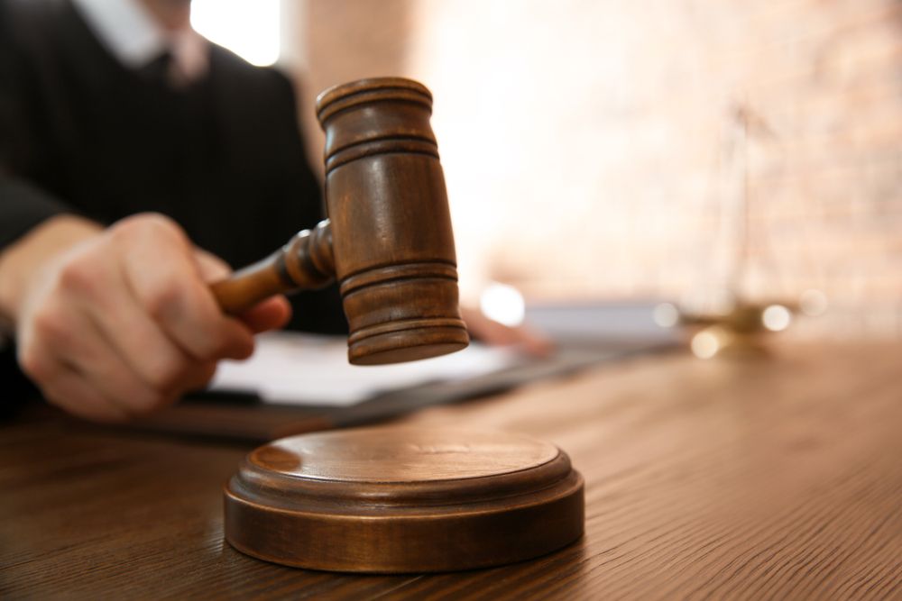 A judge slamming a gavel onto a sound block. | Source: Shutterstock