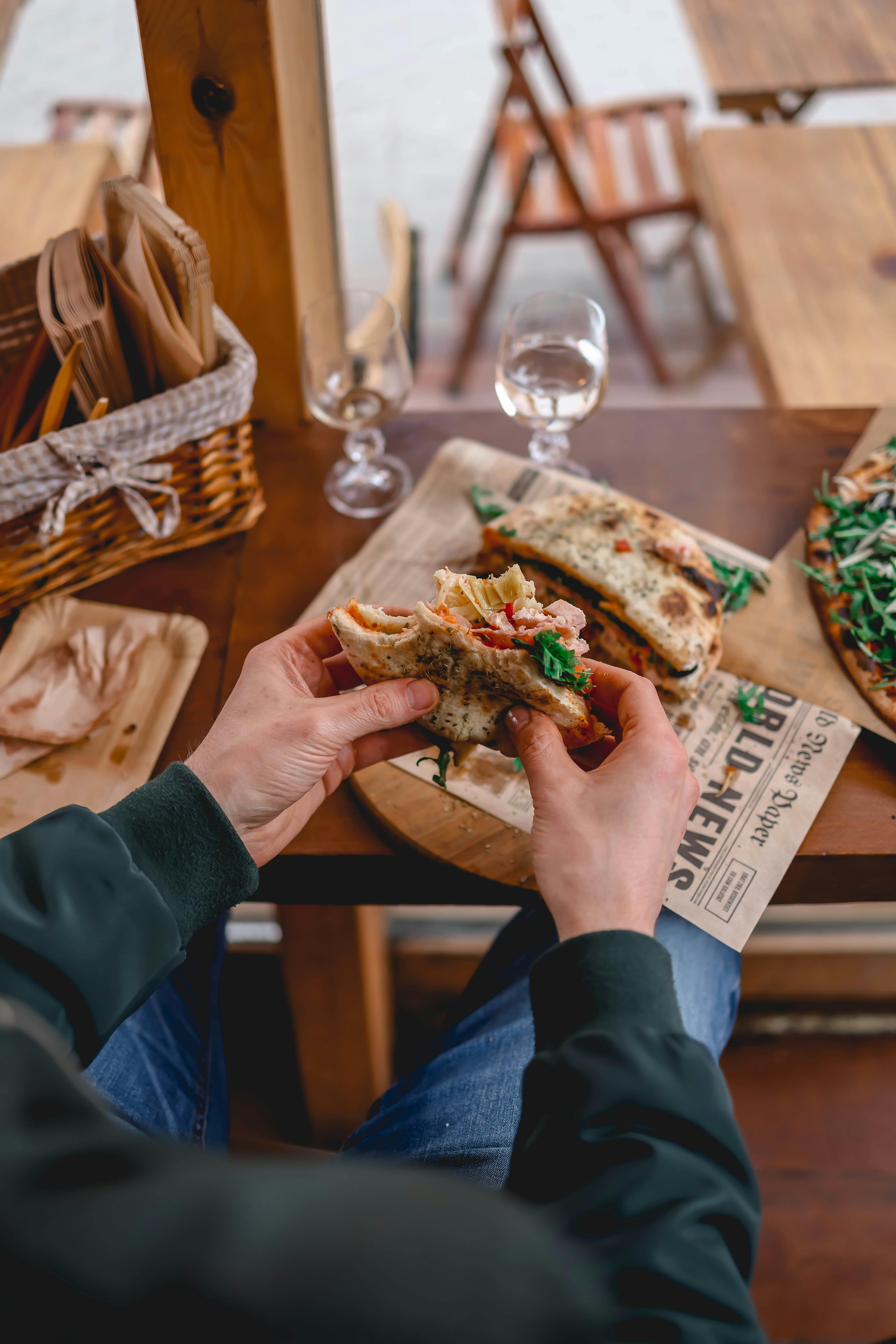 A man holding a half-eaten sandwich | Source: Pexels