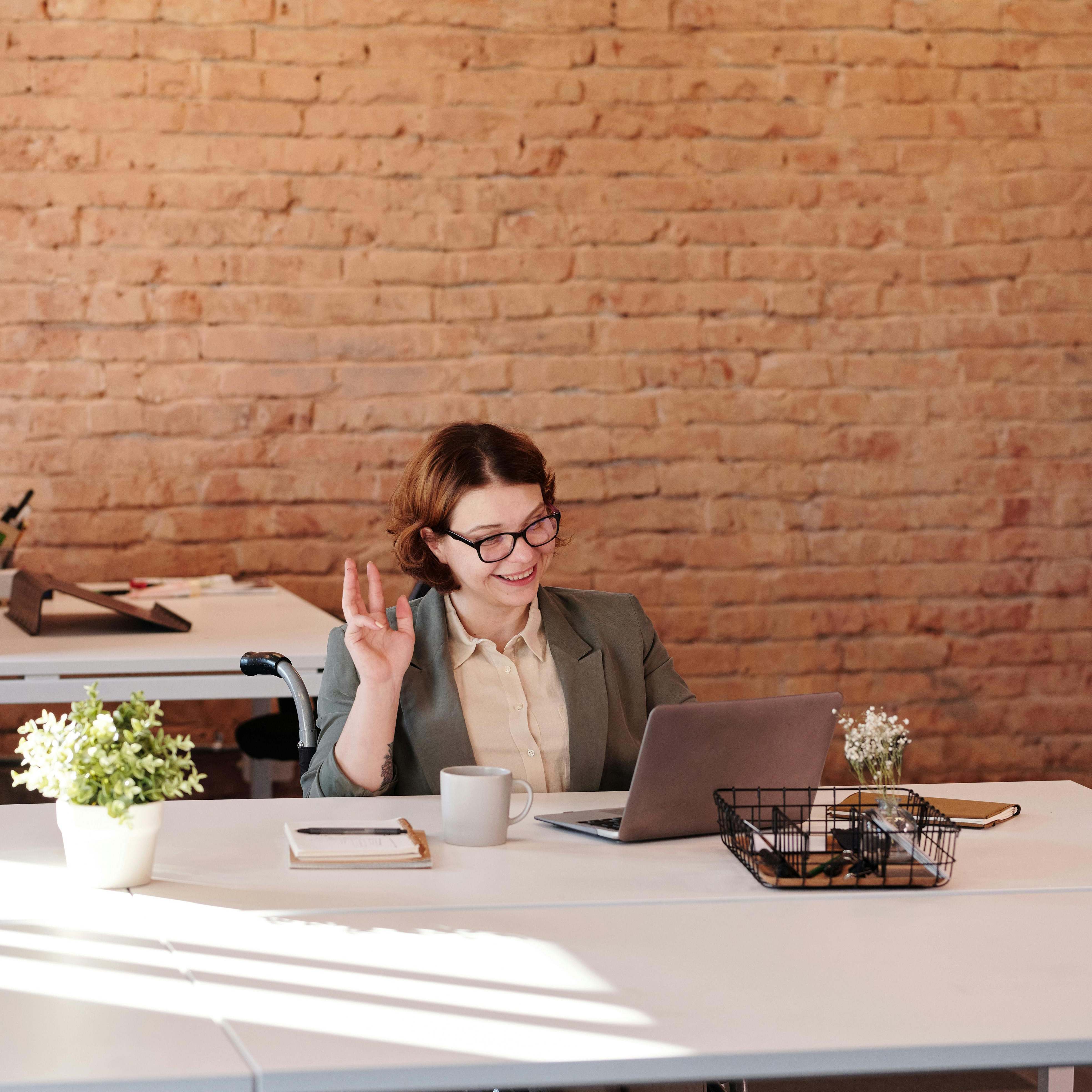 A woman at a work desk, smiling | Source: Pexels