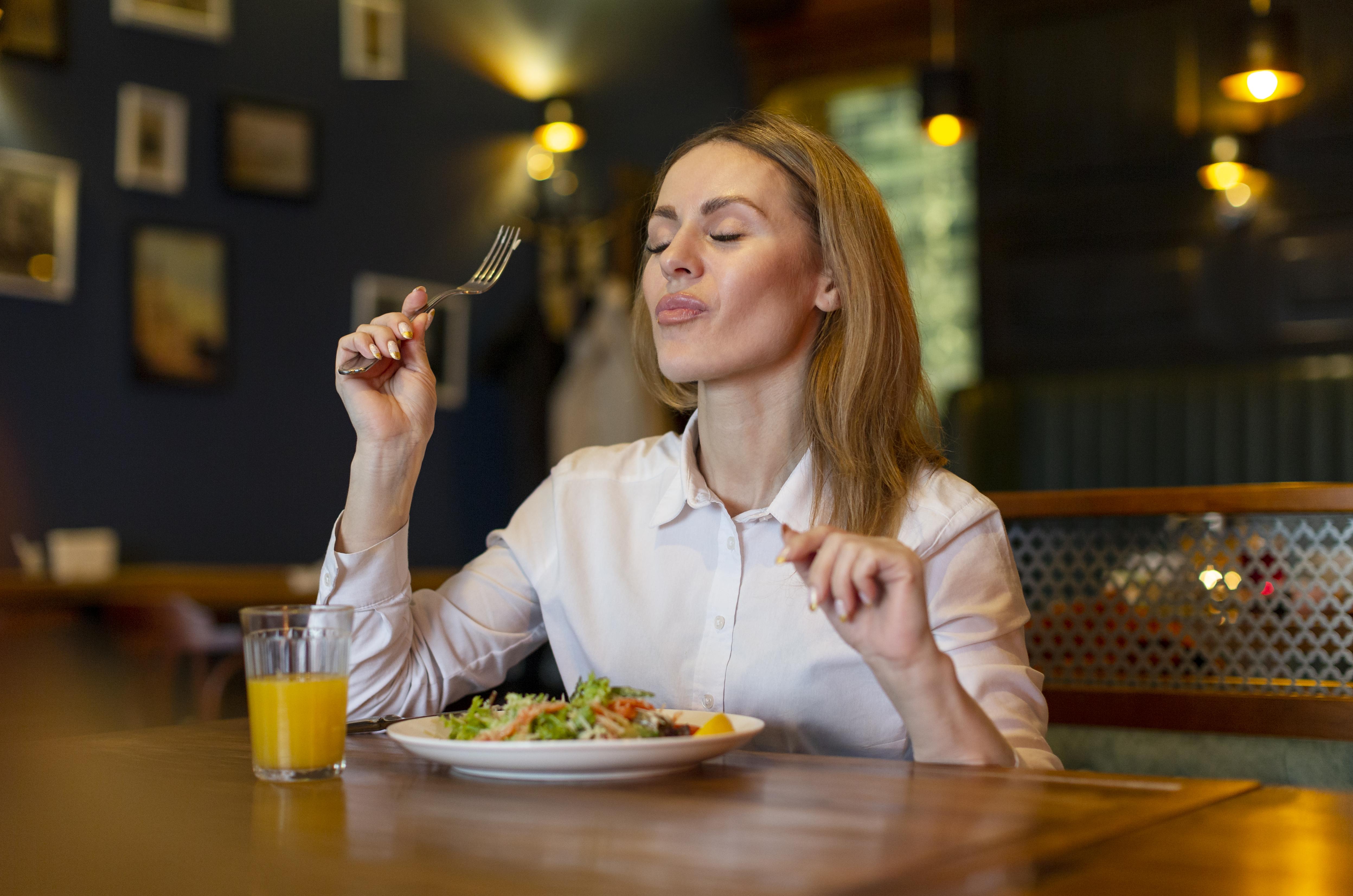 A woman enjoying her food | Source: Freepik