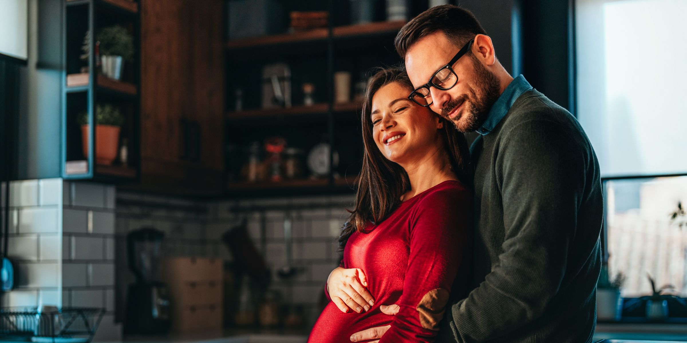 A man cradling a pregnant woman's stomach | Source: Shutterstock