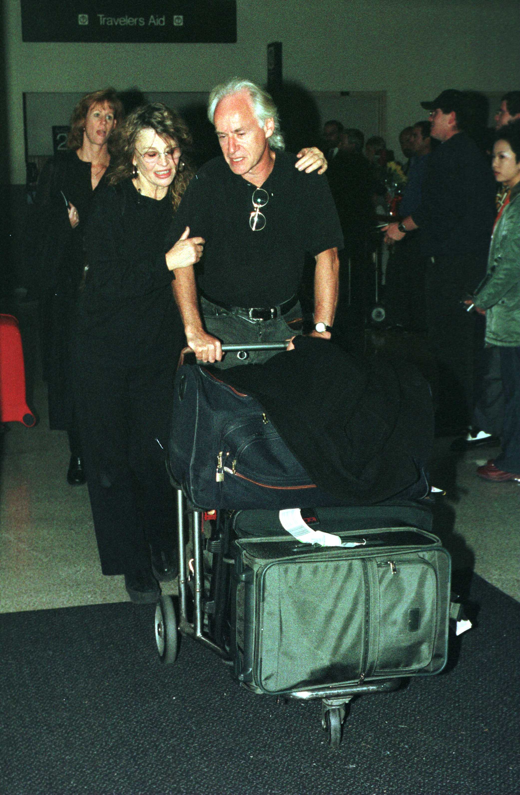 Christie arrives at Los Angeles International Airport on 11 October 2000 alongside her longtime partner, British journalist Duncan Campbell. Dressed casually for travel, Christie appears relaxed as the couple make their way through the airport, offering a rare glimpse of her life away from the spotlight.
