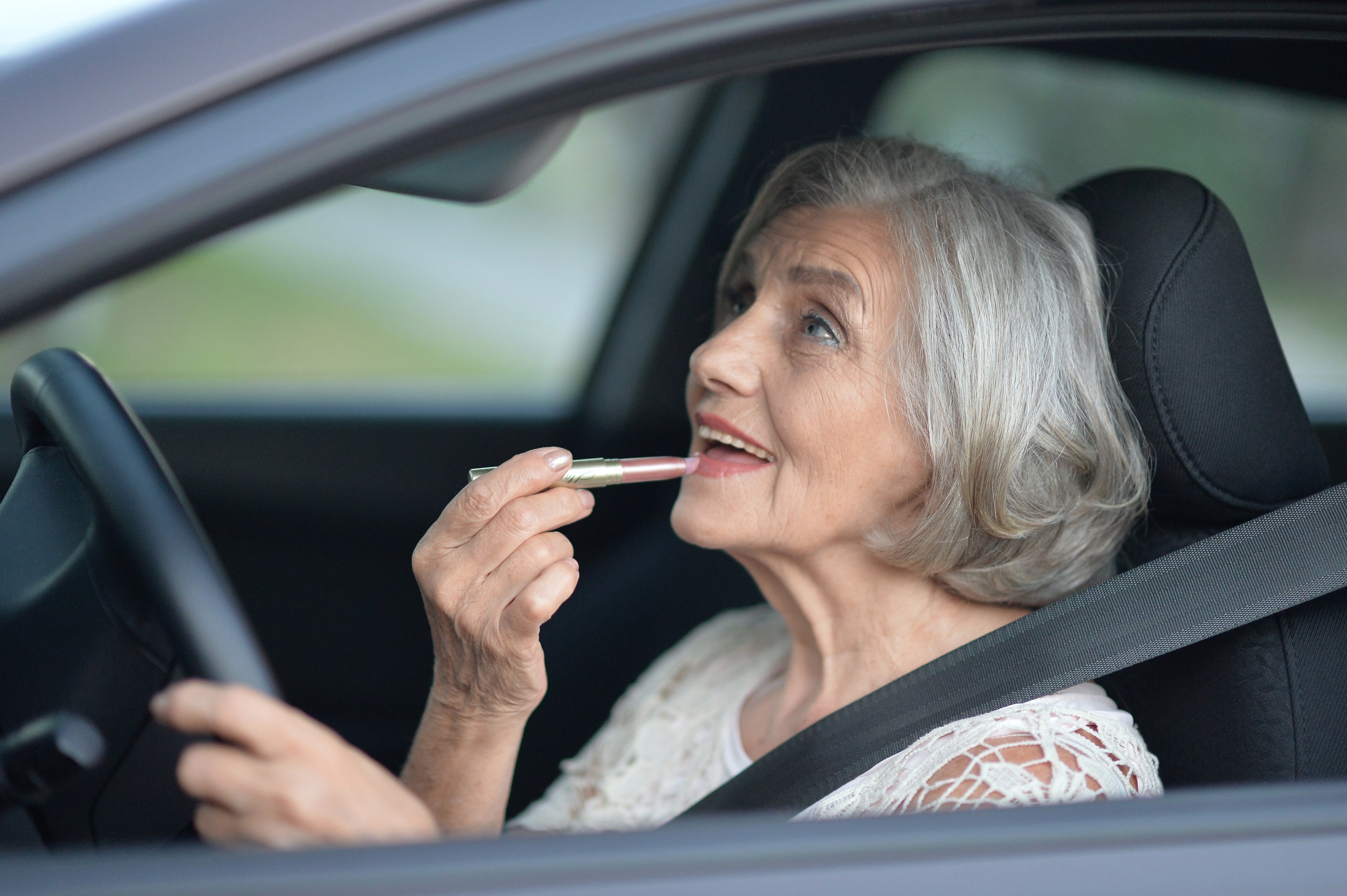 Mujer mayor se aplica lápiz labial. | Foto: Shutterstock