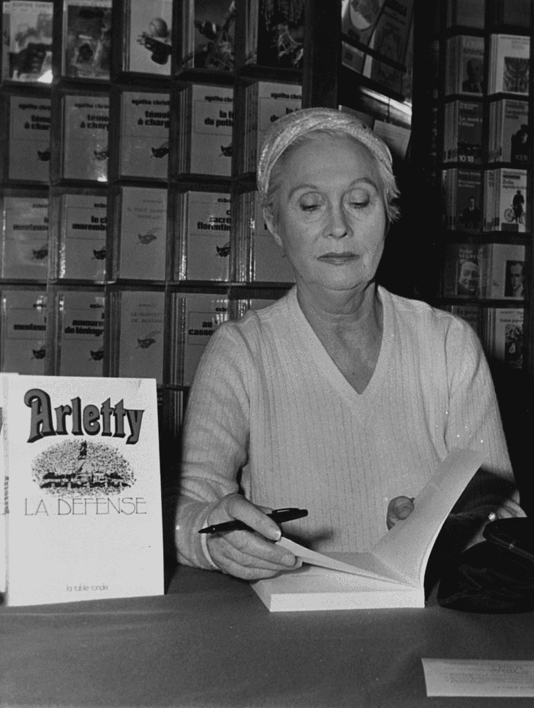 9 mars 1971: l'actrice française Arletty signe des exemplaires de son livre "La Défense" à Paris. | Photo : Getty Images