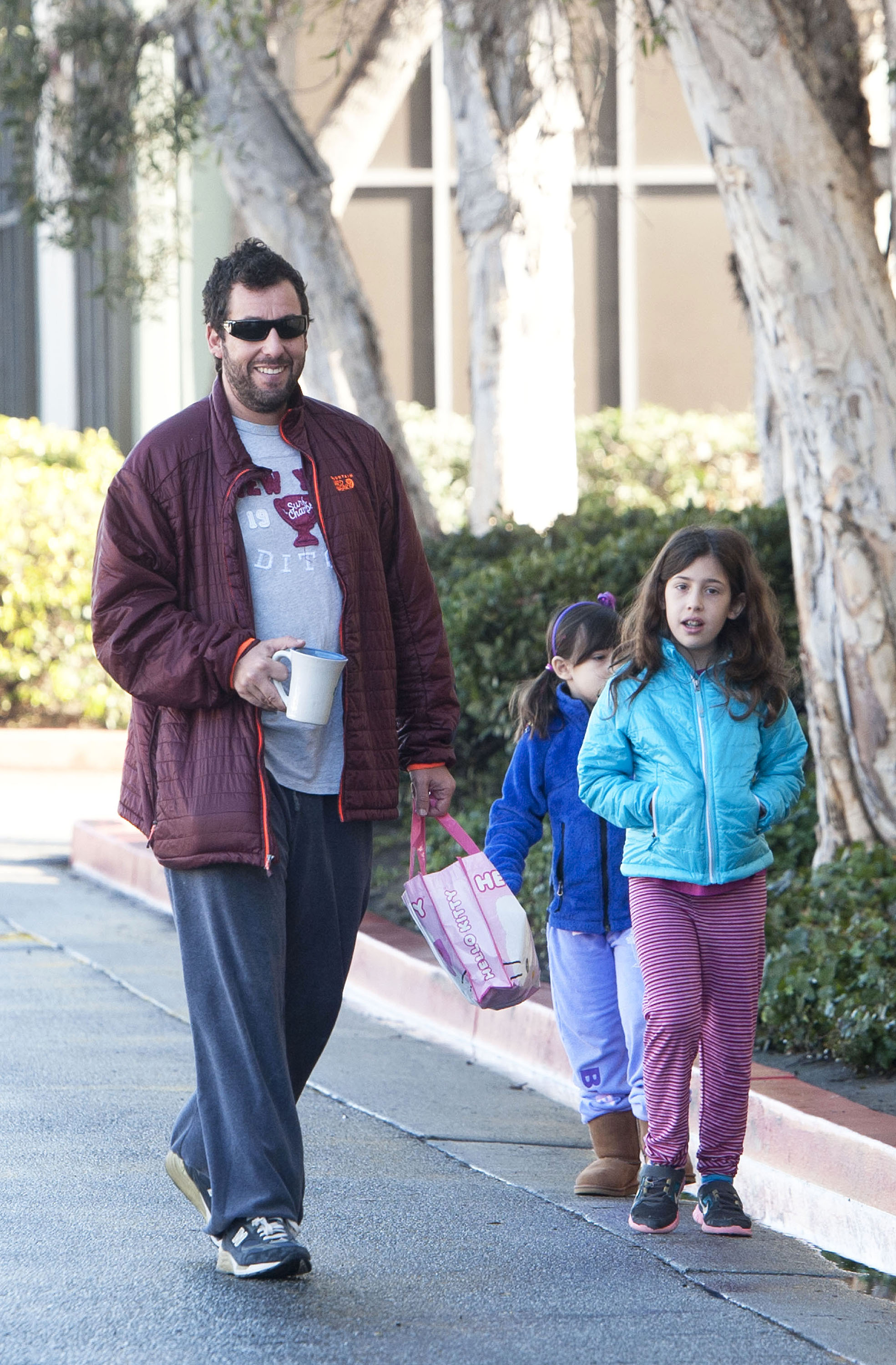 Adam Sandler with his daughters, Sadie Sandler and Sunny Sandler in Los Angeles, California on December 08, 2013 | Source: Getty images