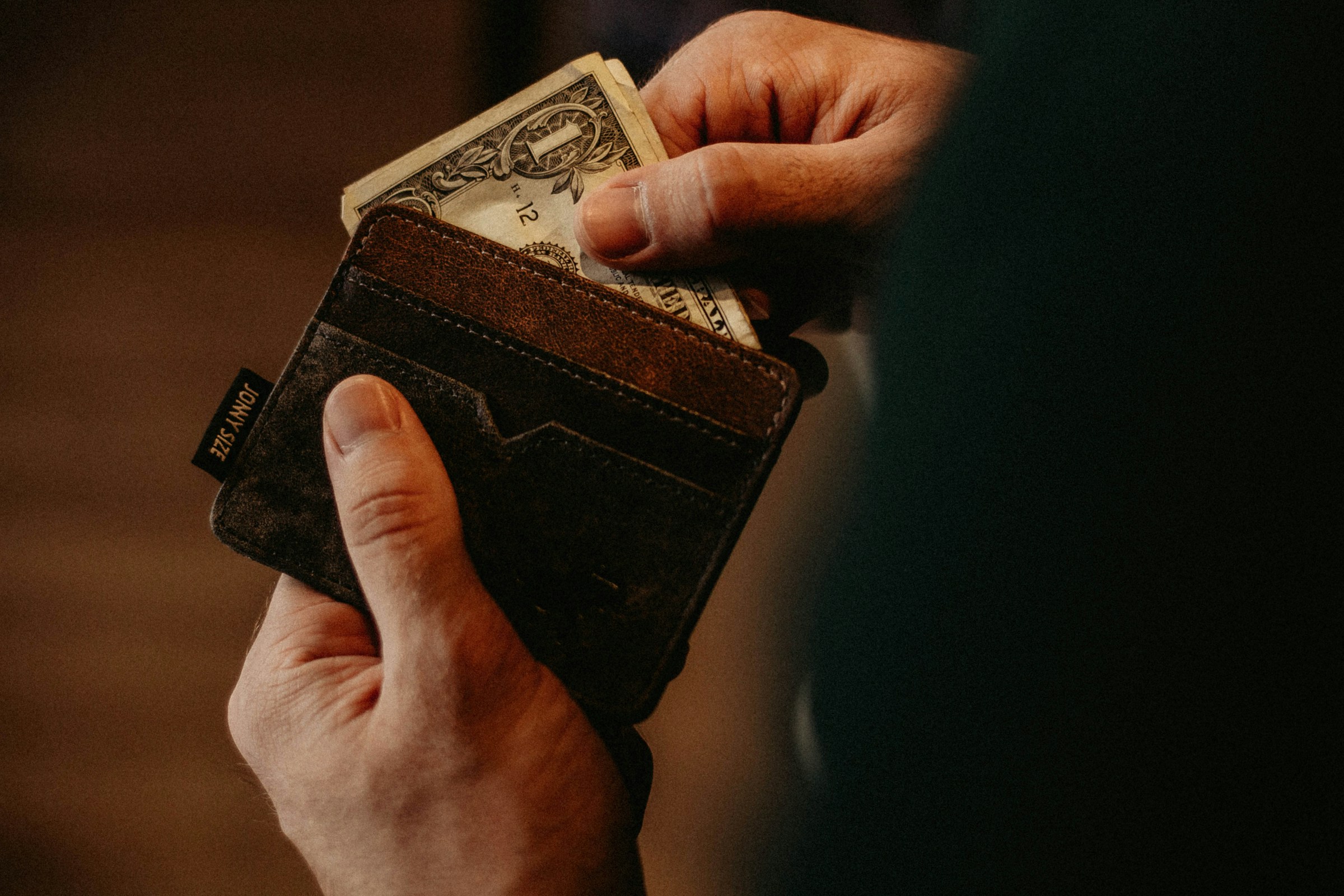 A man opening his wallet | Source: Unsplash