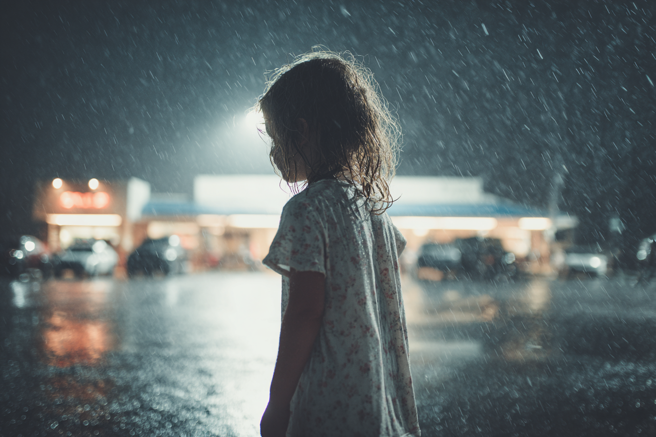 A little girl standing in the rain | Source: Midjourney