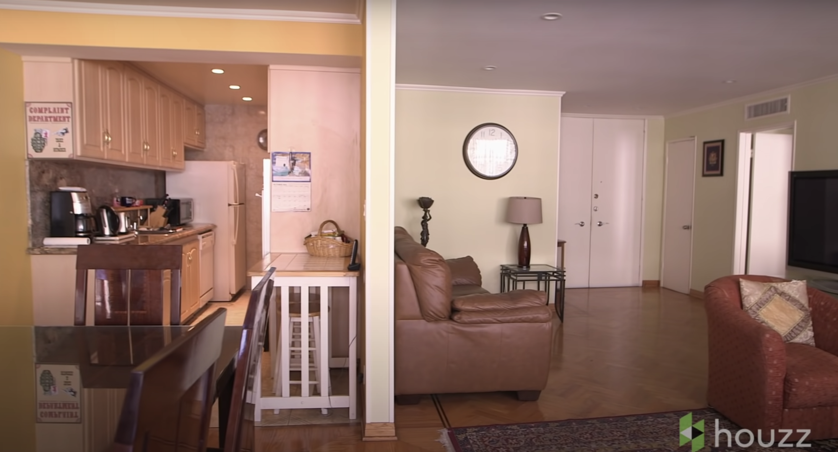 The kitchen area and living room are separated by a wall before the renovation. | Source: Youtube.com/HouzzTV
