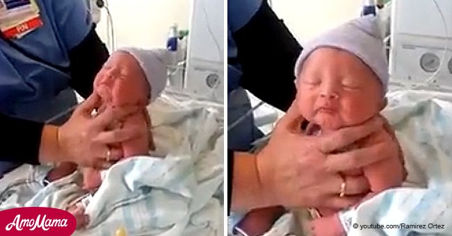 Nurse helps burp a baby boy. When she pats his back, he releases a hilarious sound