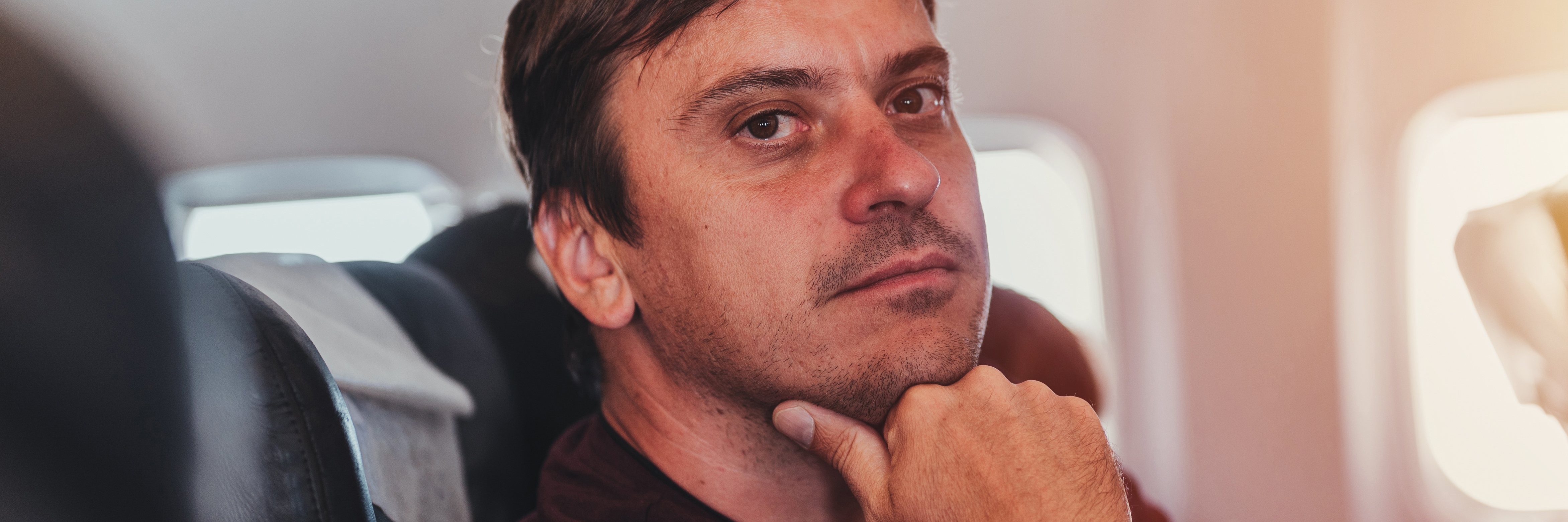 Thoughtful and guilty man inside a plane | Source: Shutterstock