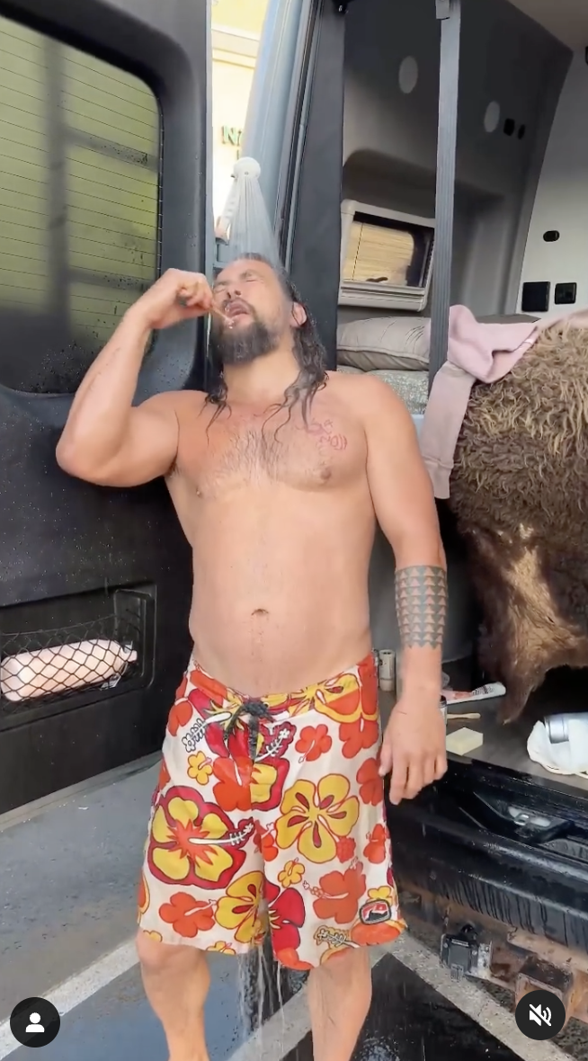 Jason Momoa is pictured brushing his teeth and taking a quick shower from the showerhead hanging from his van's door. | Source: instagram.com/prideofgypsies/