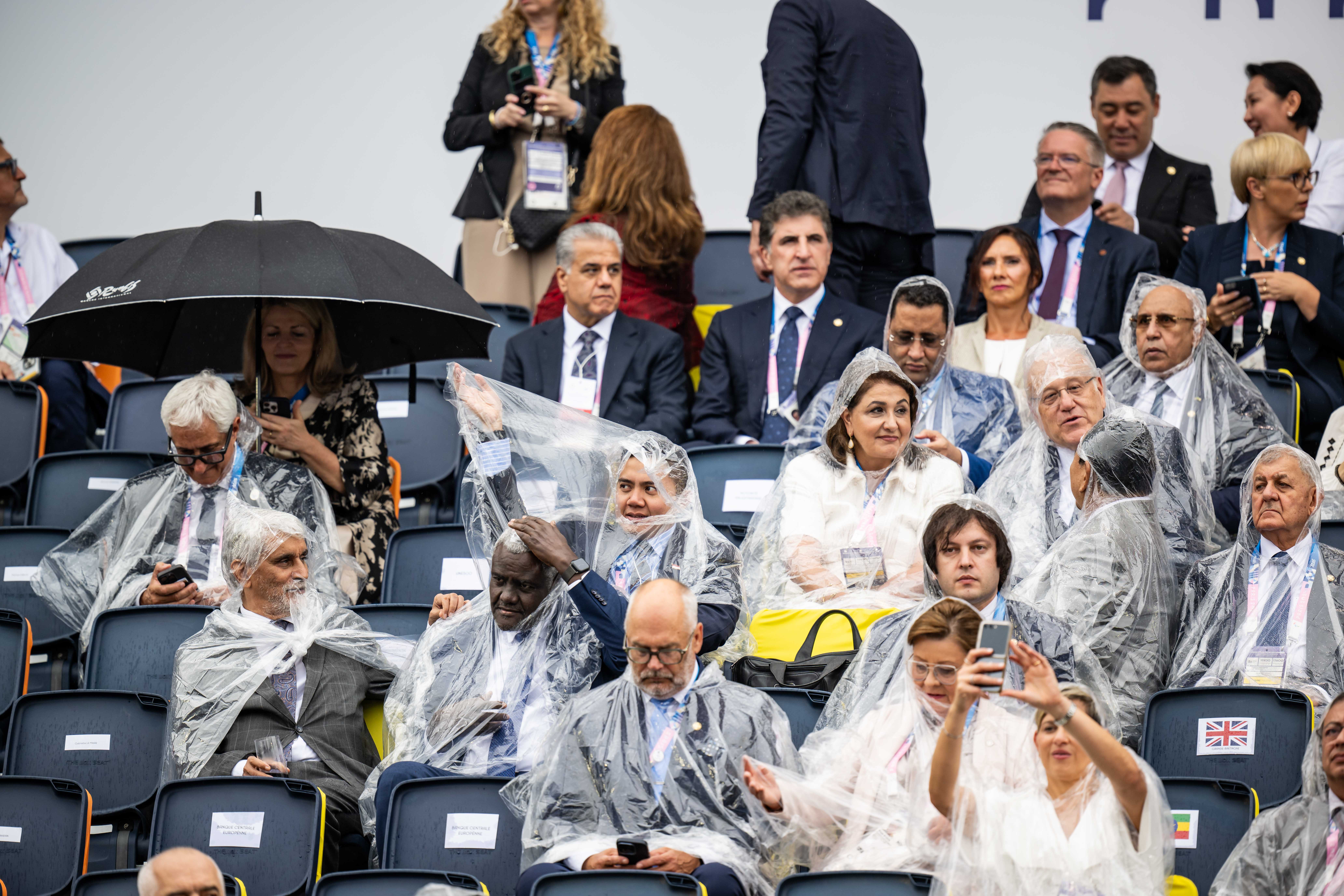 Peolpe sit on a tribune at Trocadero with heavy rain bevor the Opening Ceremony of the Olympic Games Paris 2024 in Paris, France, on July 26, 2024. | Source: Getty Images