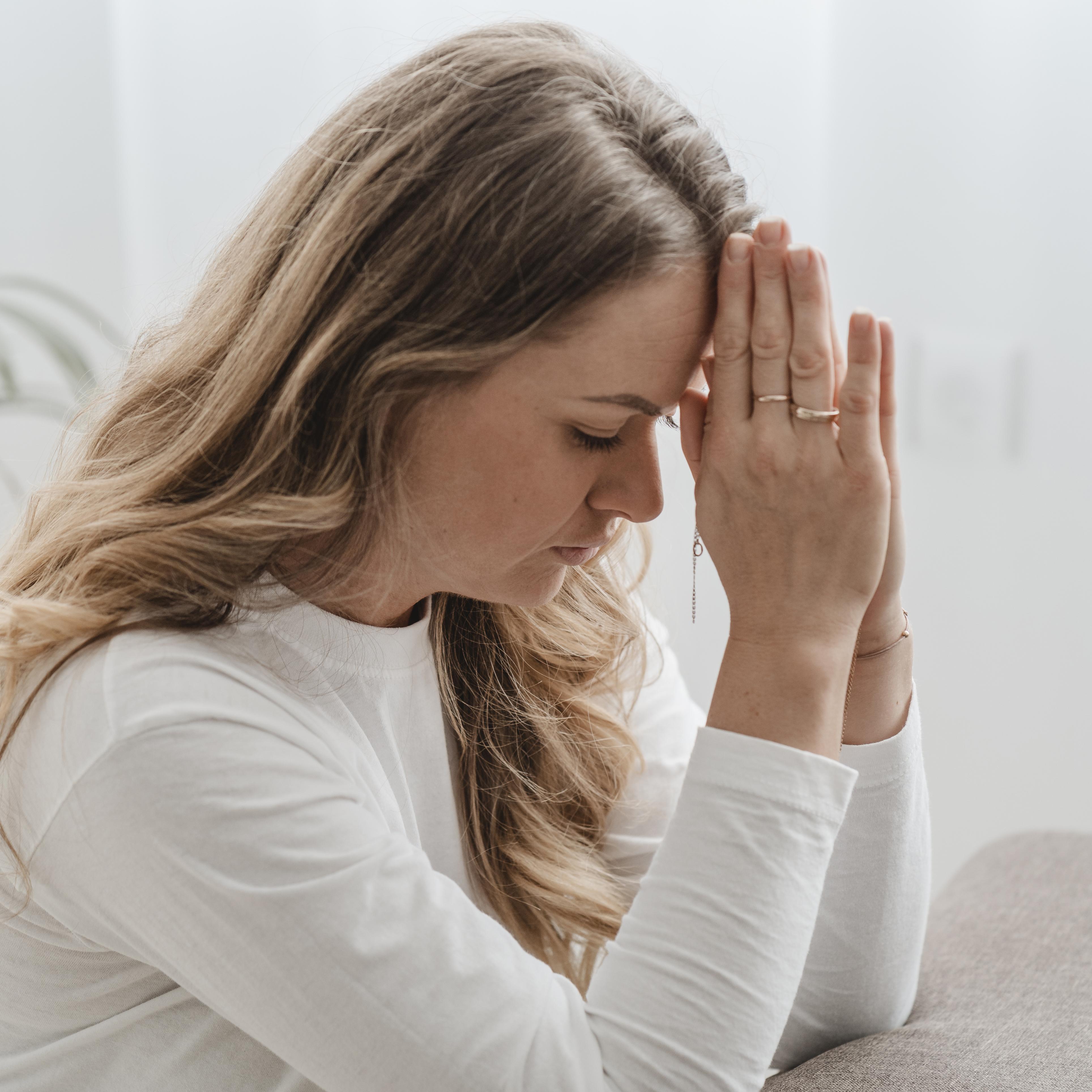 A woman praying | Source: Freepik