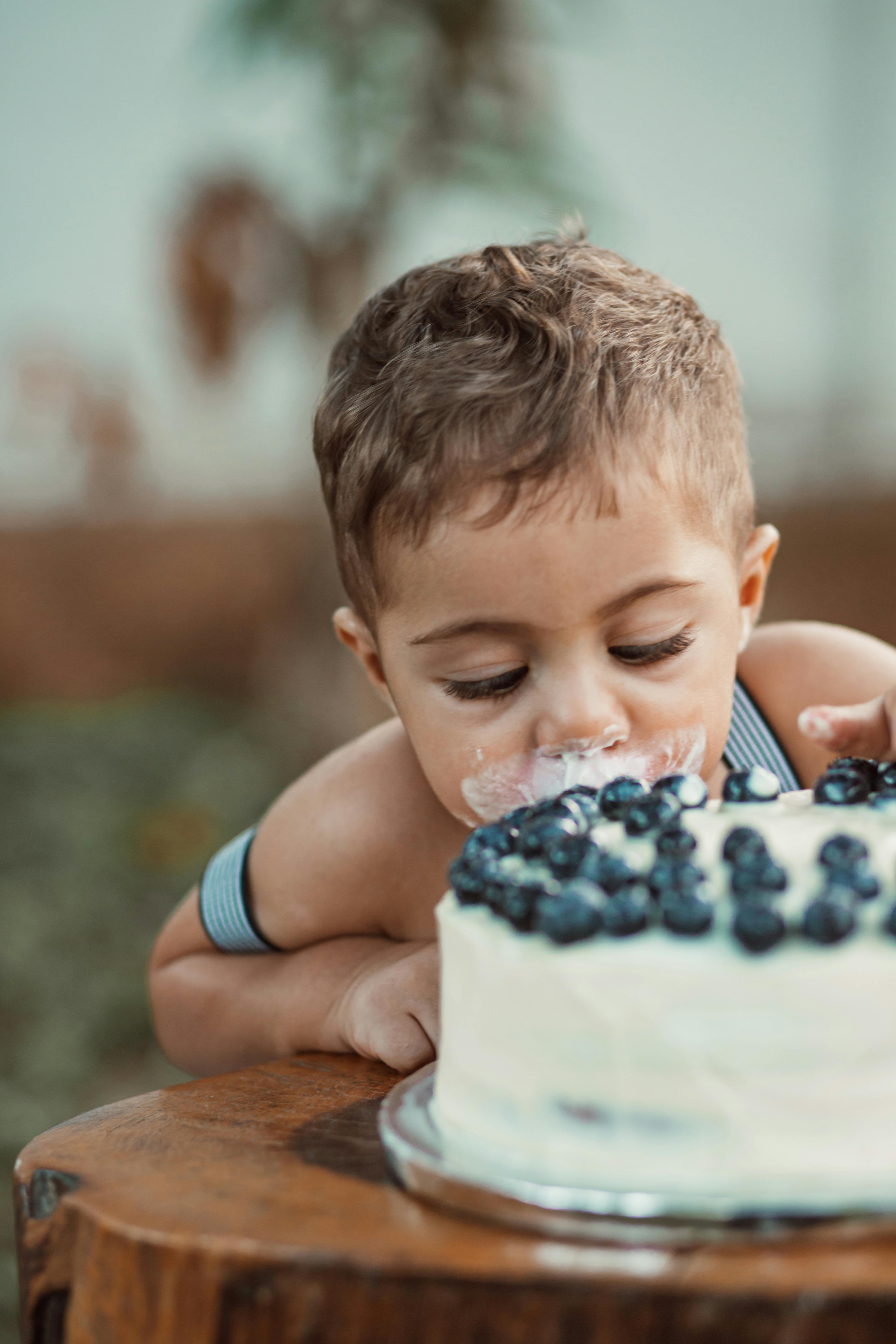 A child biting into a cake | Source: Pexels