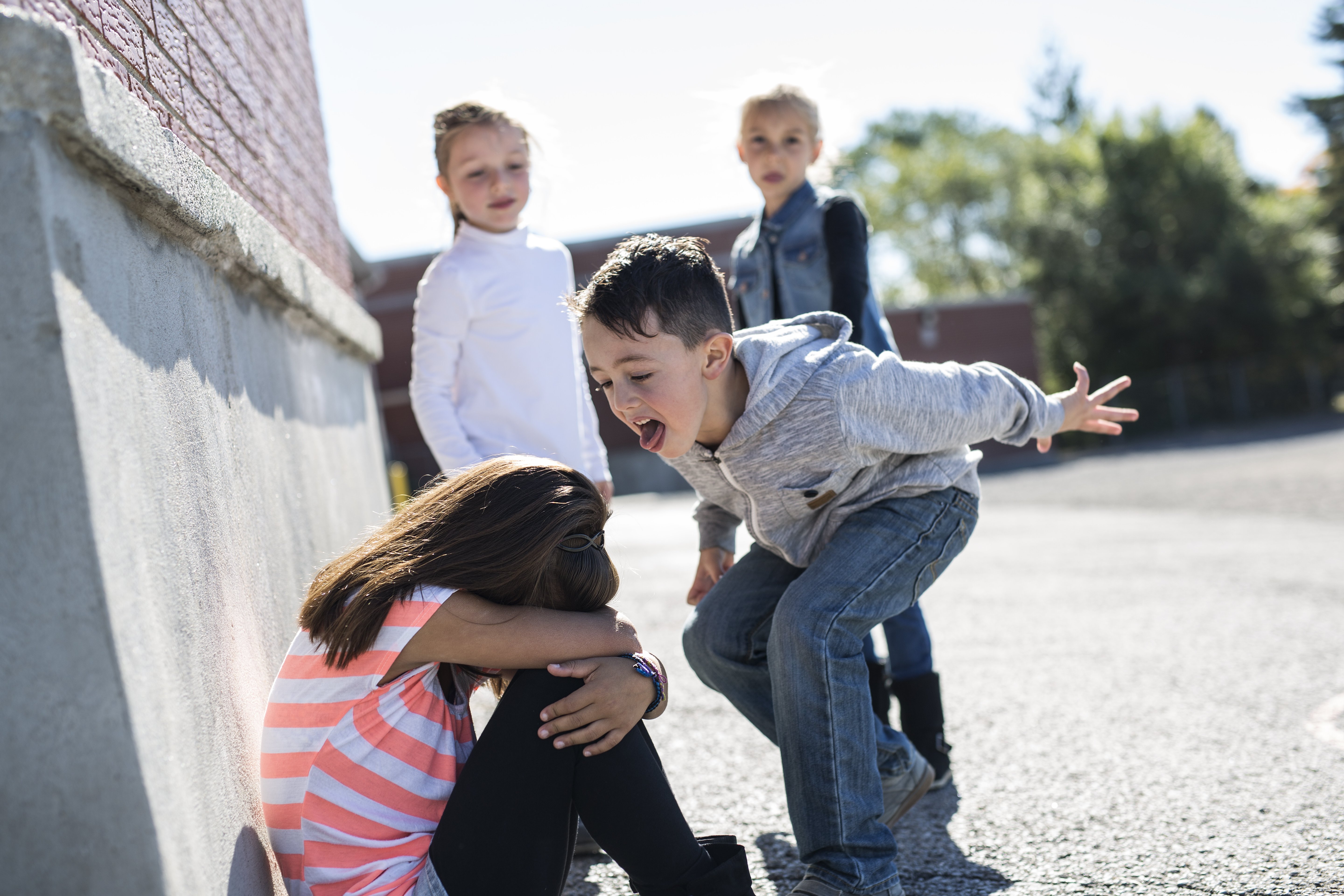 Niña triste siendo víctima de bullying escolar en medio del recreo. Fuente: Shutterstock Niña triste siendo víctima de bullying escolar en medio del recreo. Fuente: Shutterstock