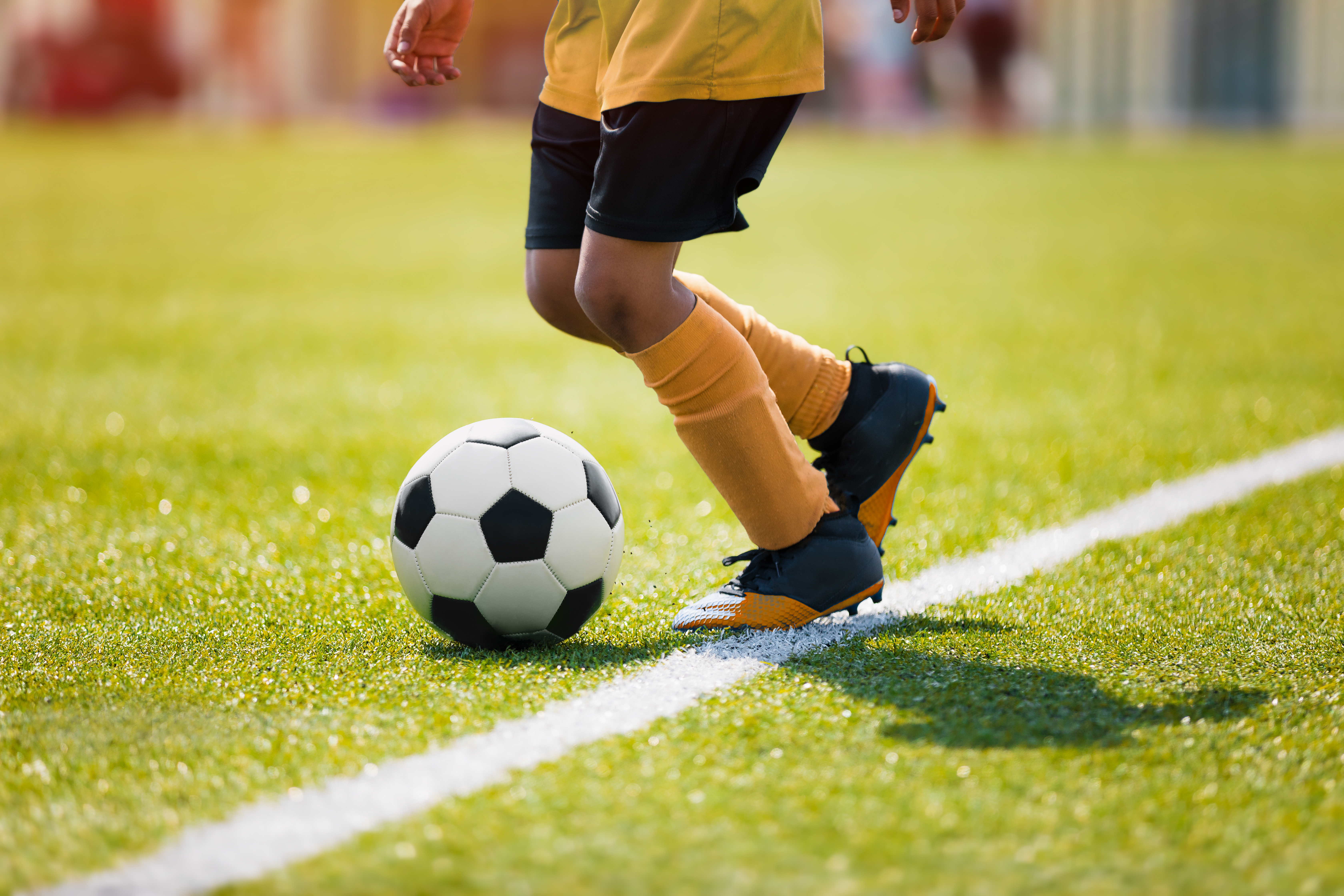 A young child playing soccer on a field | Source: Shutterstock