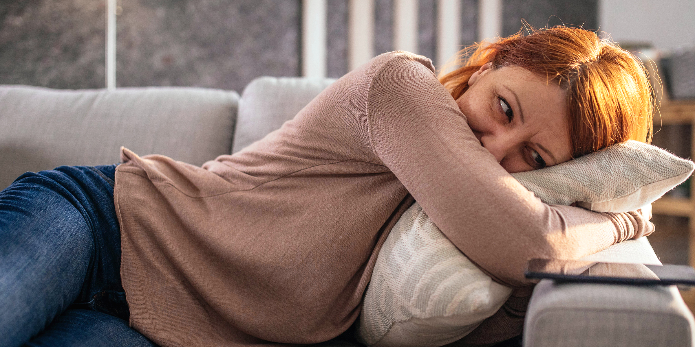 Stressed woman resting on the couch | Getty Images