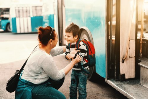 A mother talking to her son before the board a bus. | Source: Shutterstock.