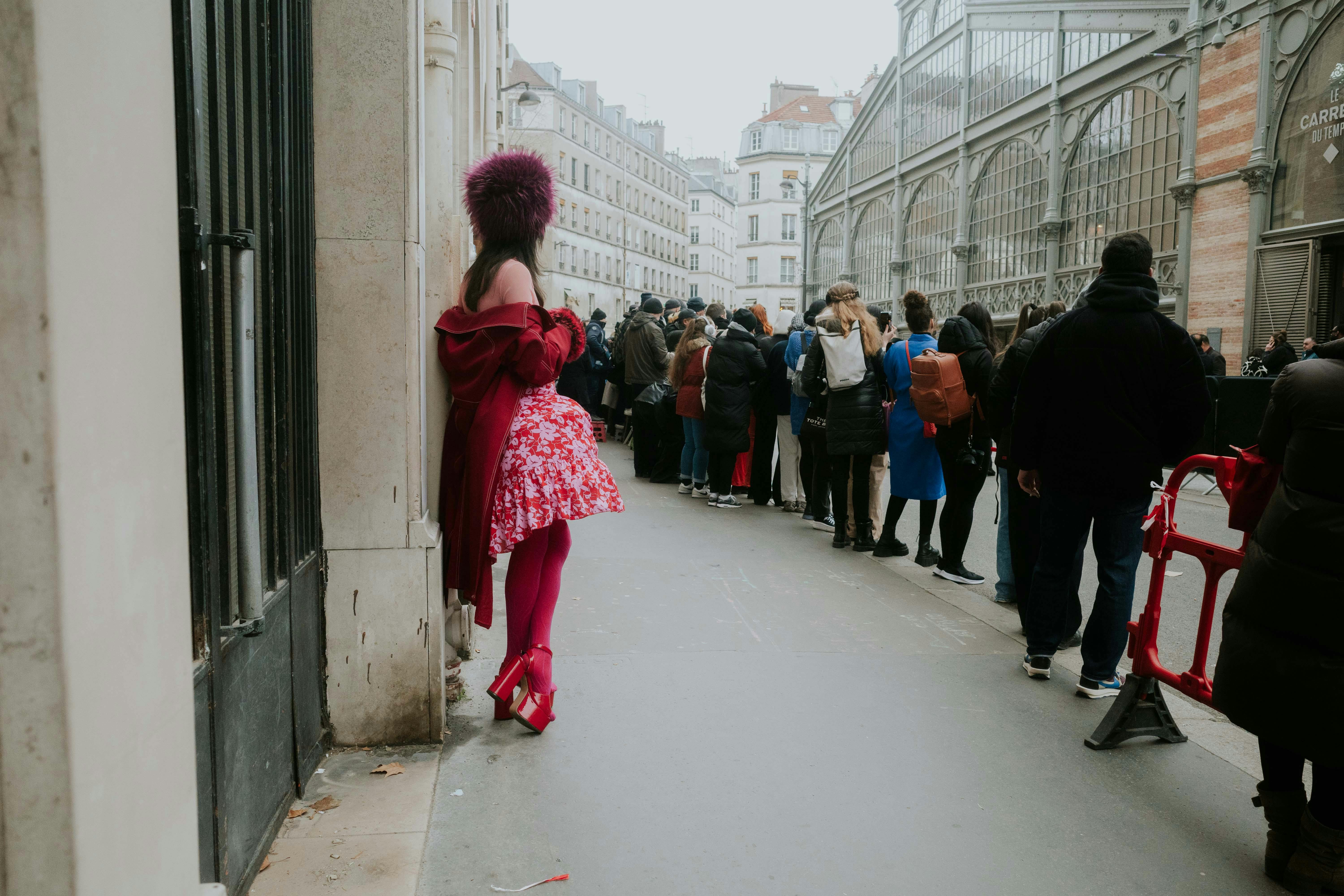 A woman standing near a long queue. | Source: Pexels