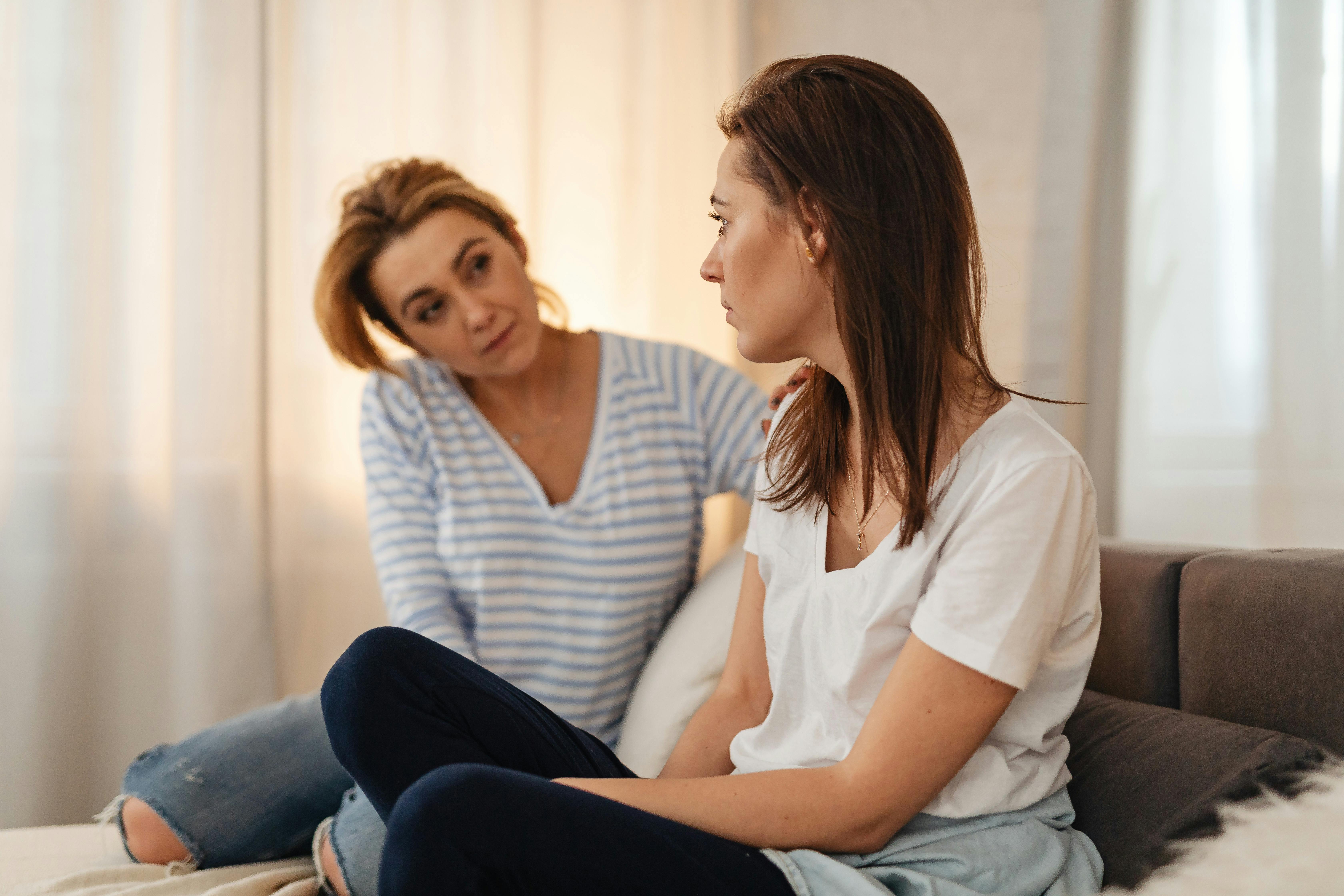 A mother and her grownup daughter talking on the couch | Source: Pexels