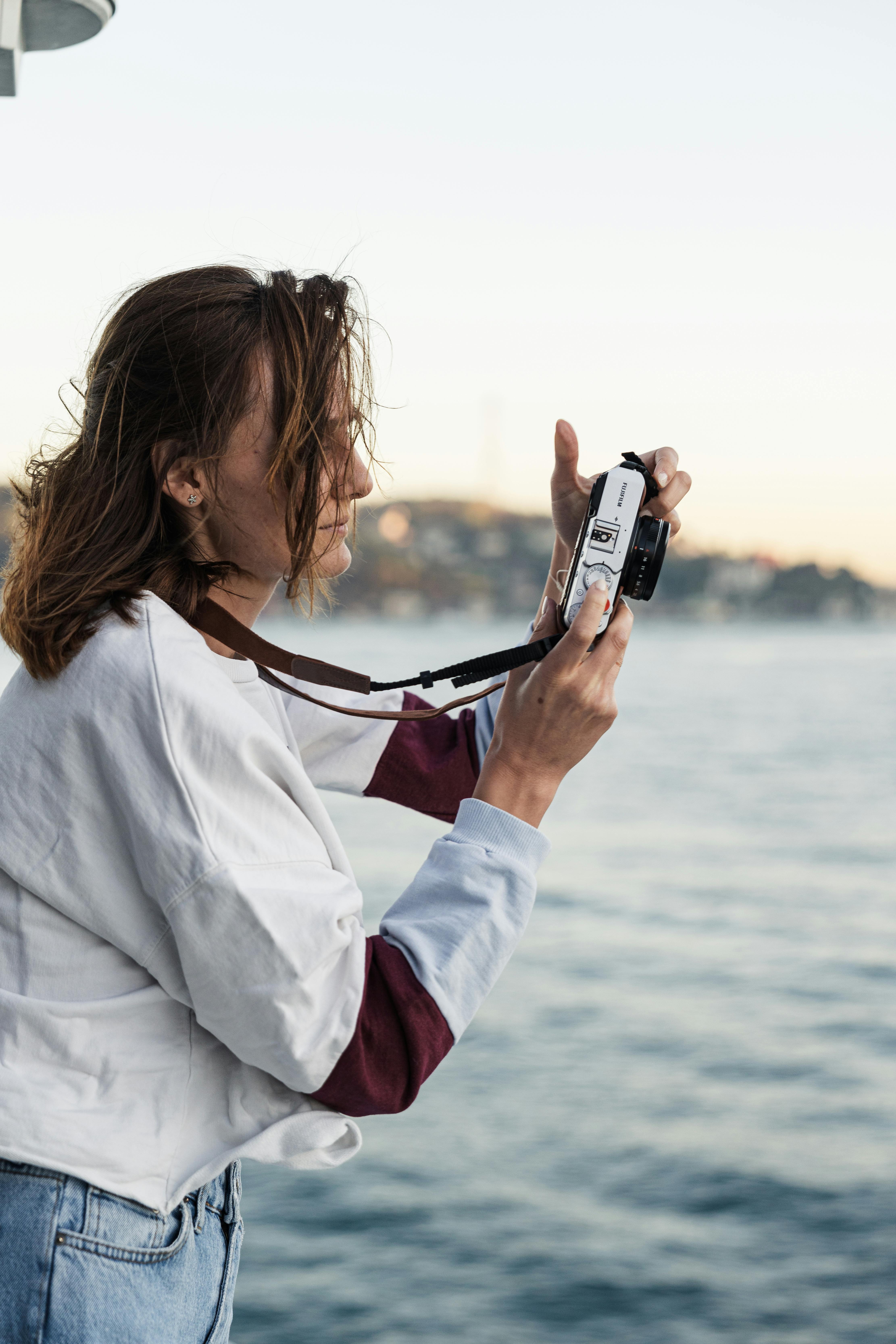 Woman takes a photo on the beach | Source: Pexels