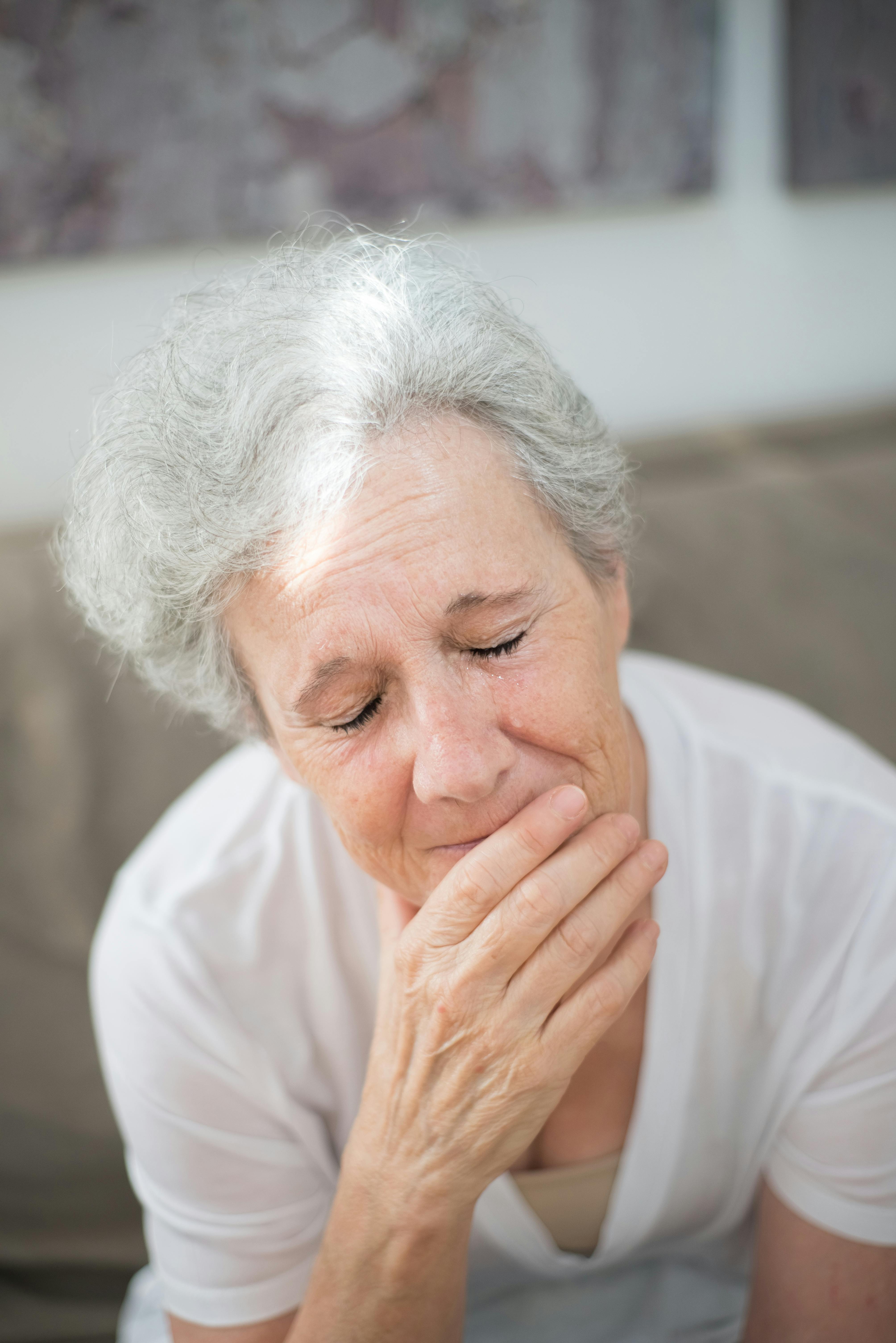 An upset older woman crying with her eyes closed | Source: Pexels