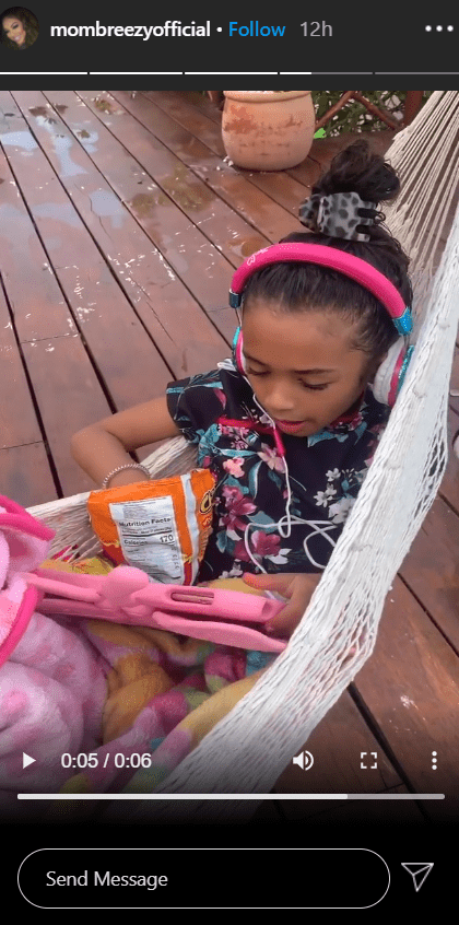 A picture of Royalty relaxing in a hammock while using her tab. | Photo: Instagram/Mombreezyofficial