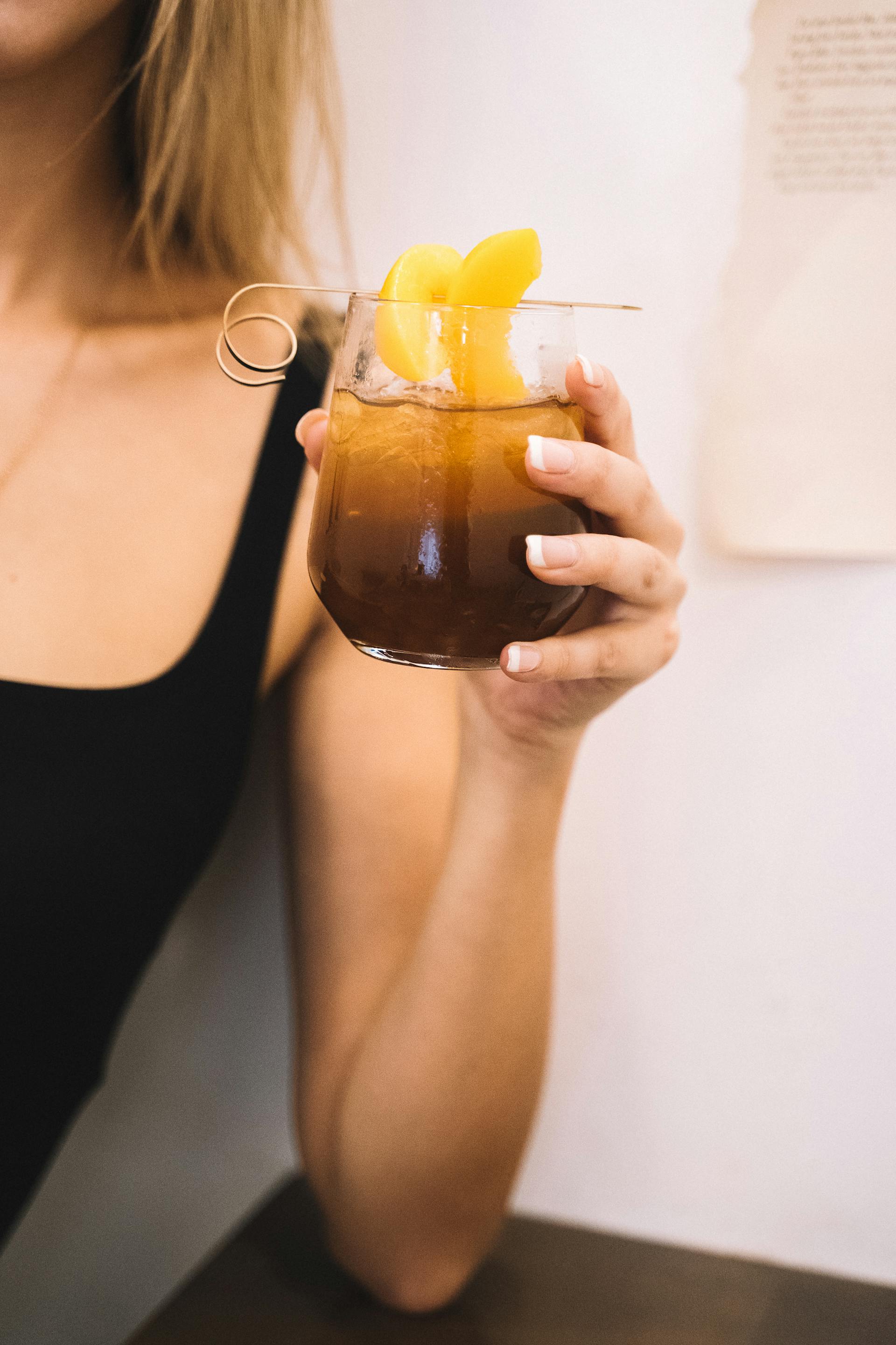 A woman holding a cup of iced tea | Source: Pexels