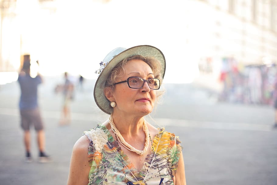 Mujer usando un sombrero y lentes formulados mientras camina. | Foto: PxFuel