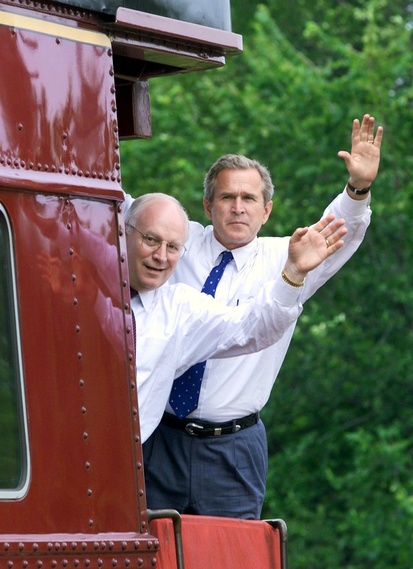 George W. Bush and Dick Cheney wave from their three-day Midwest campaign train in Battle Creek, Michigan, on August 5, 2000 | Source: Getty Images