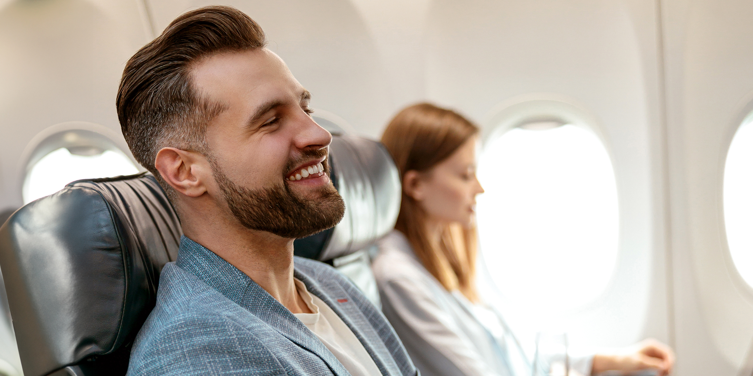 A man and woman alongside each other on an airplane flight | Source: Shutterstock